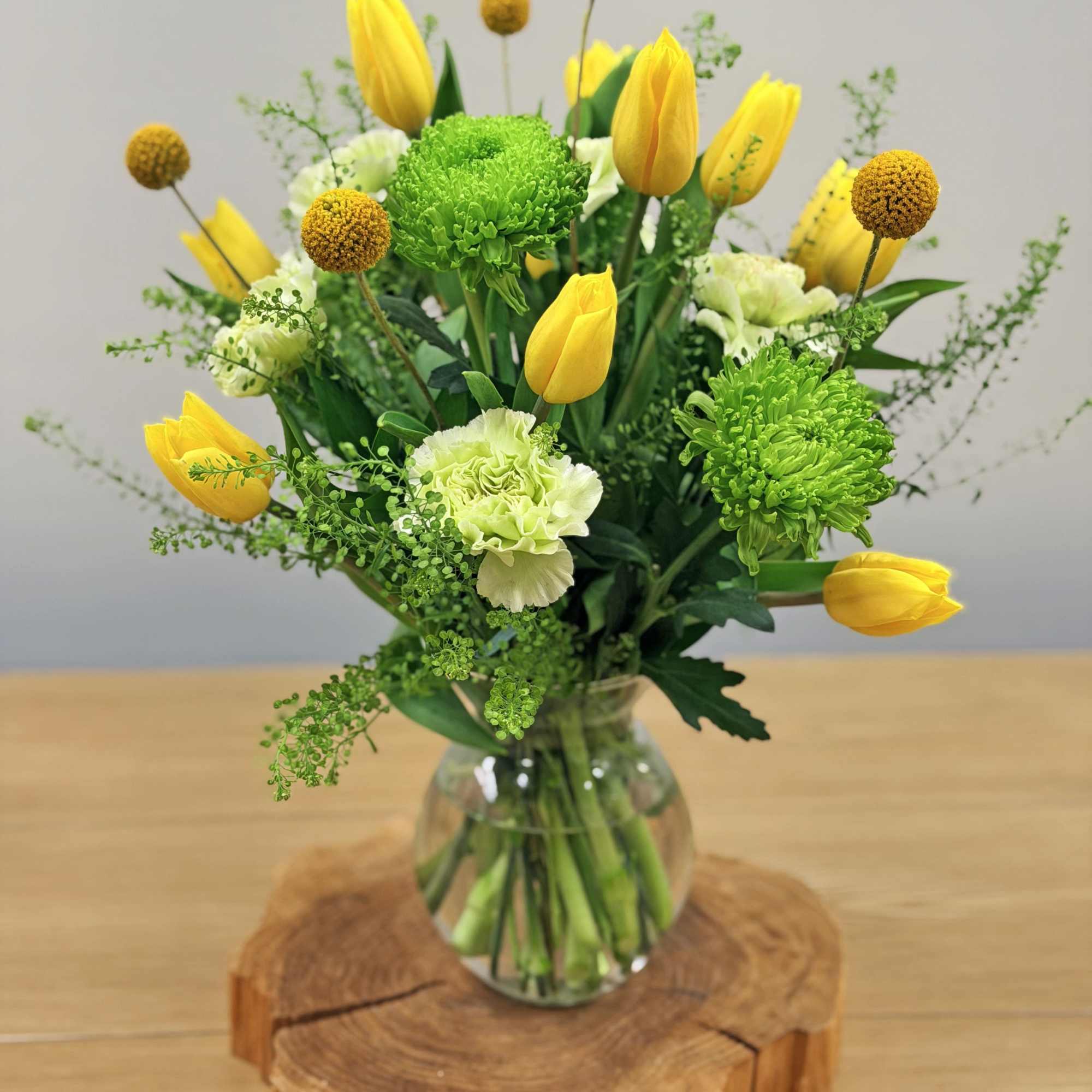 Bright yellow tulips take center stage in this spring-ready flower arrangement, perfect