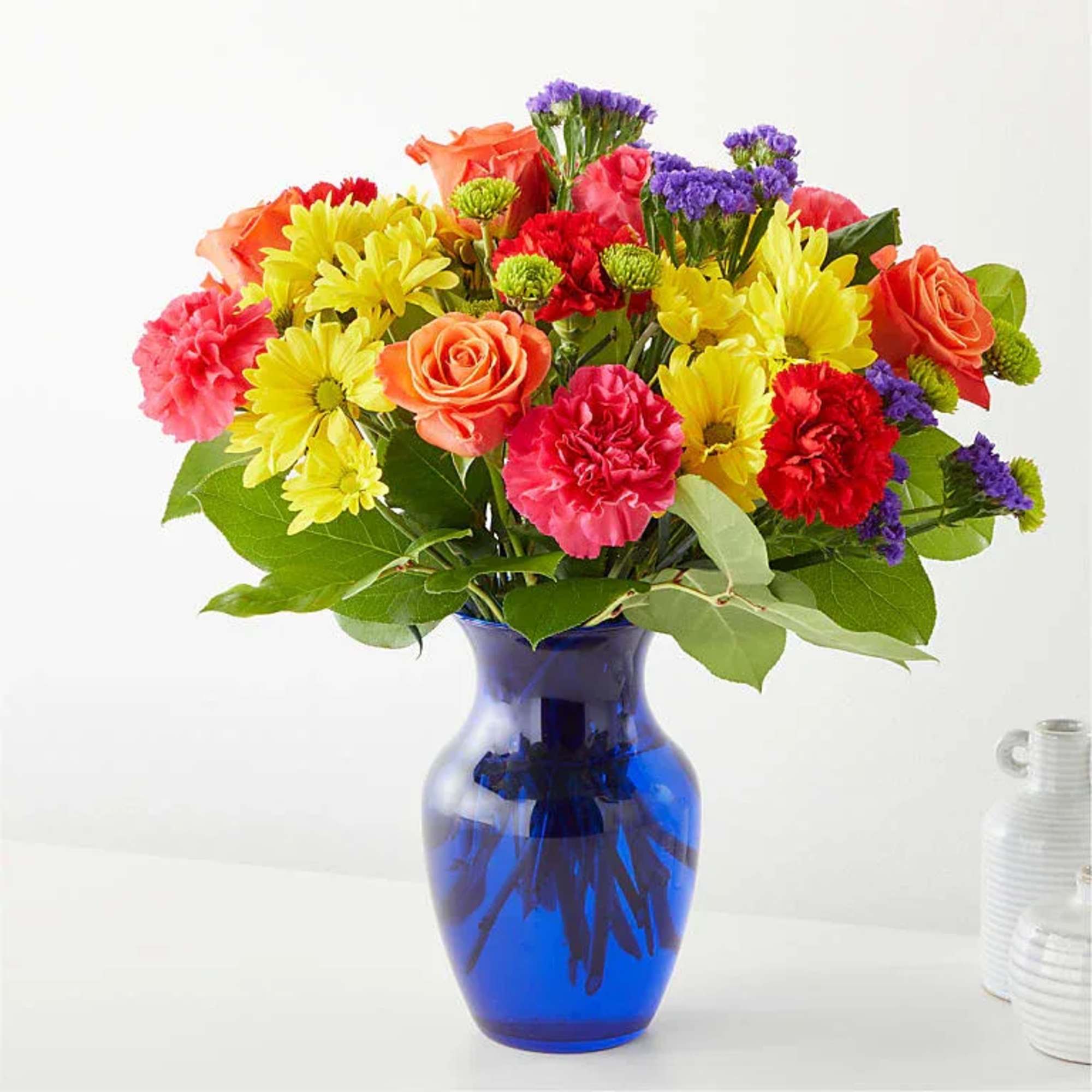 Bright, cheerful, and full of personality, this lush rounded arrangement features sunny