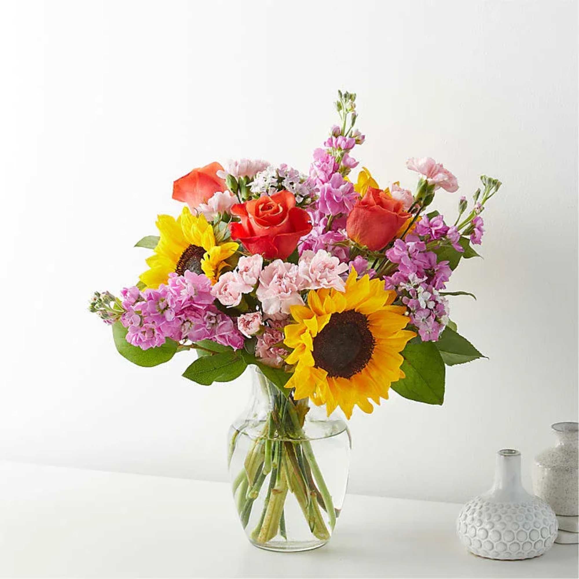 Bring warmth and happiness to any occasion with this vibrant garden-style arrangement.