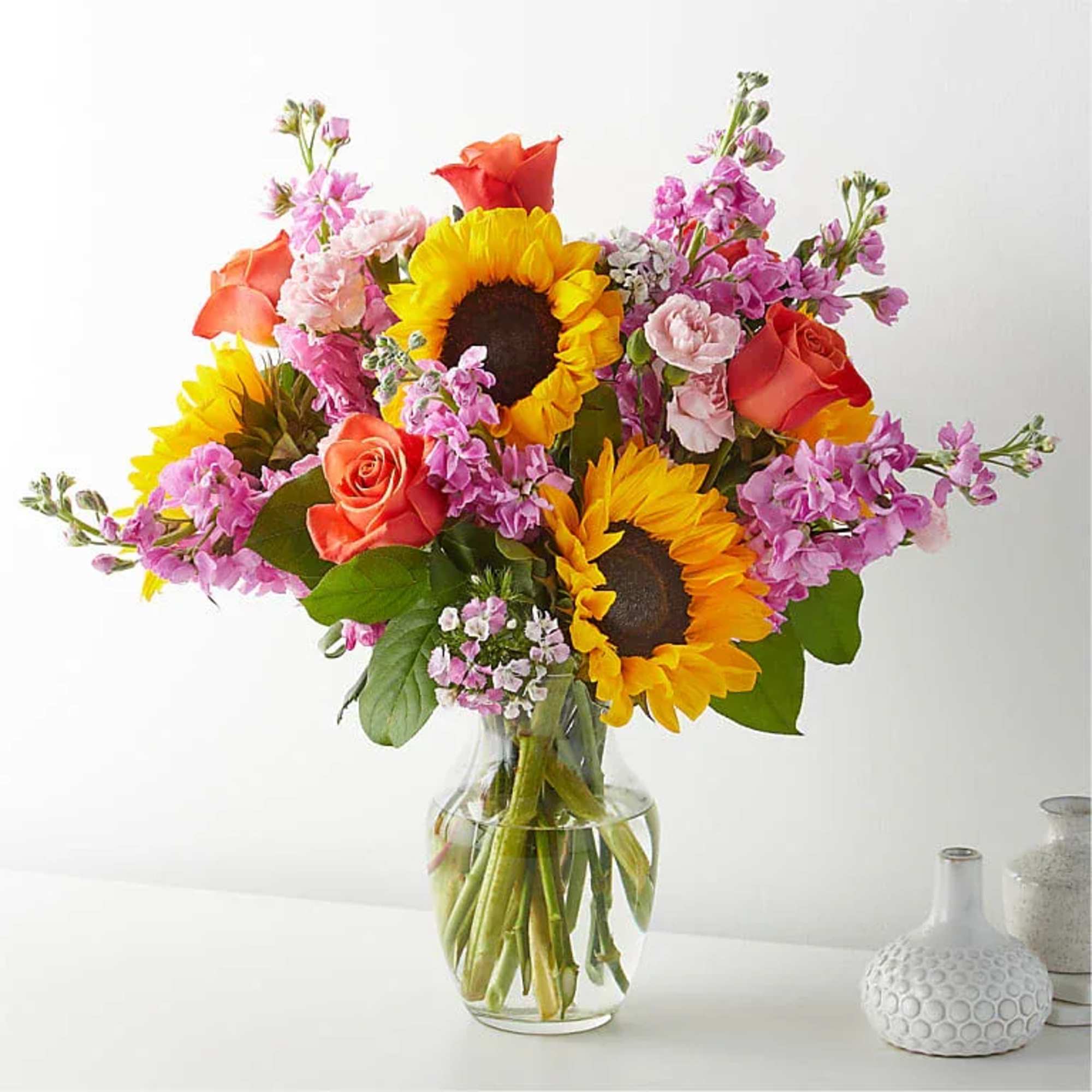 Bring warmth and happiness to any occasion with this vibrant garden-style arrangement.
