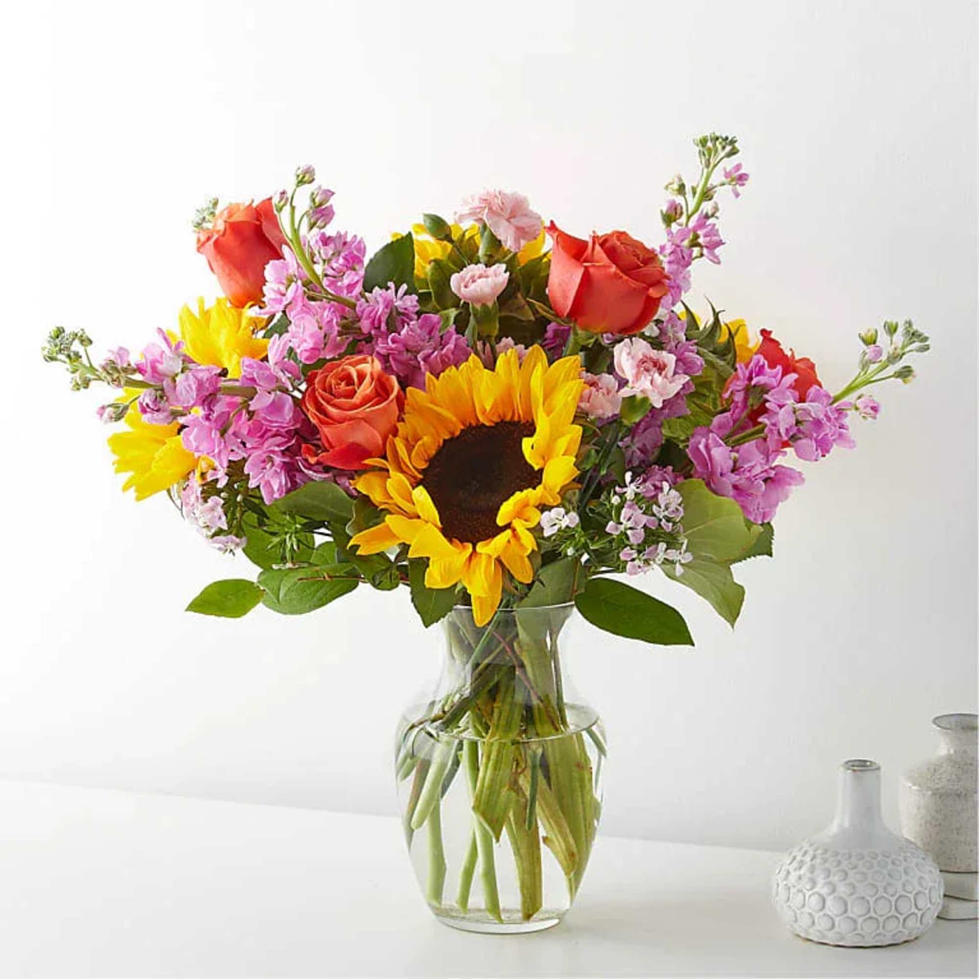 Bring warmth and happiness to any occasion with this vibrant garden-style arrangement.