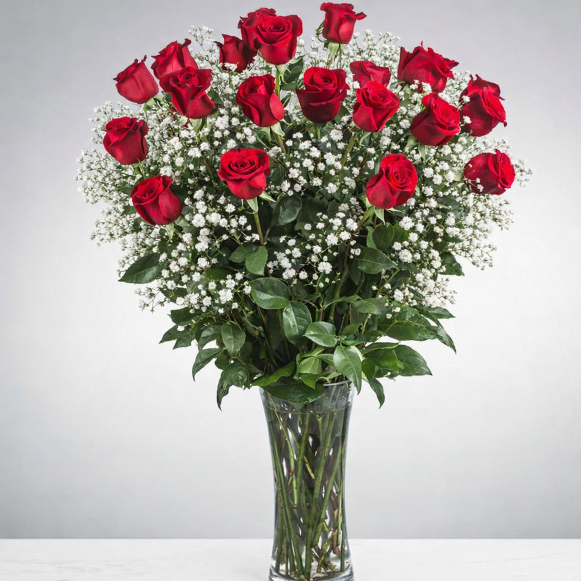 Tall vase arrangement of red roses with white baby's breath