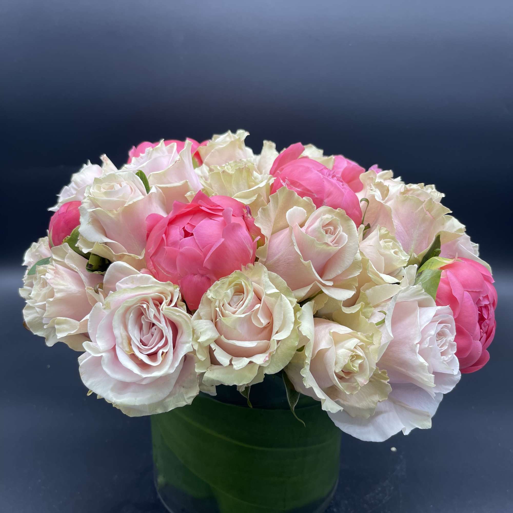 Pink and white roses arranged in a green vase