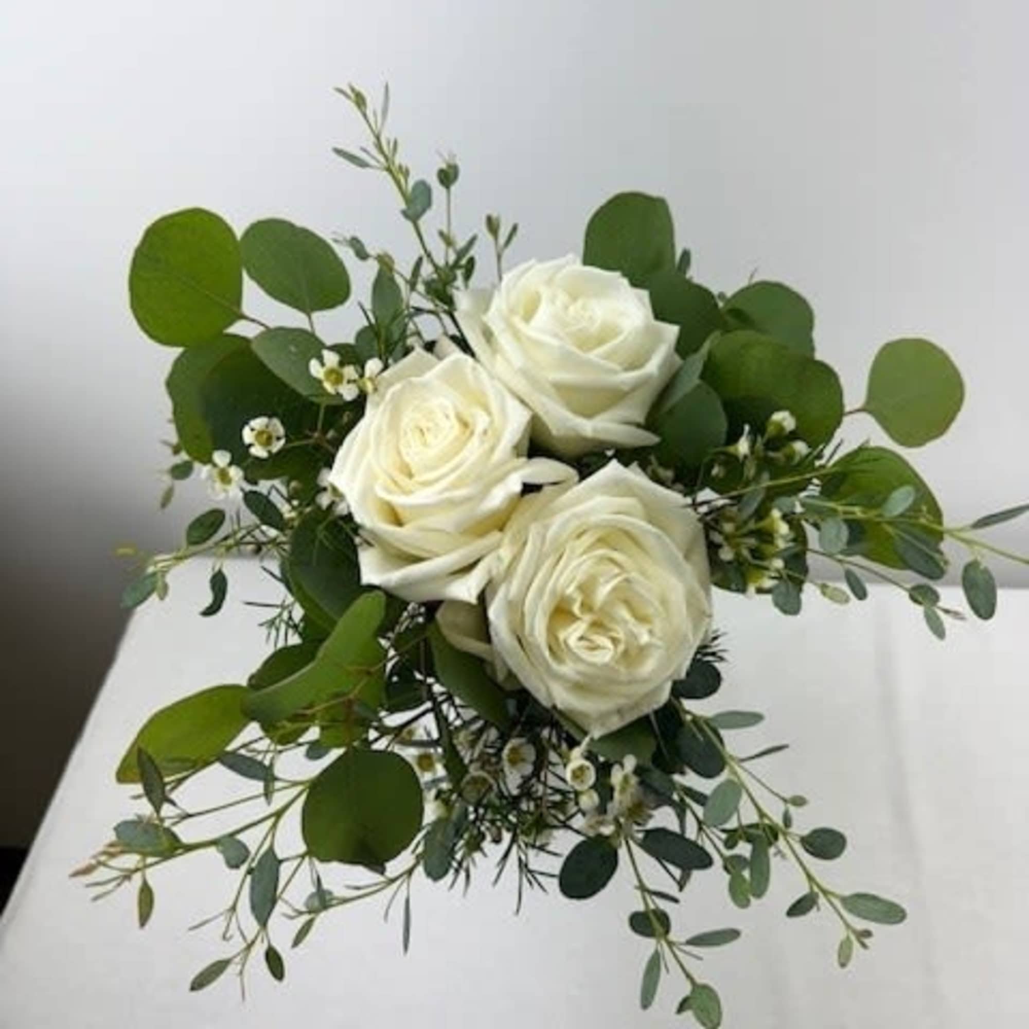 Bouquet of white roses with round green foliage