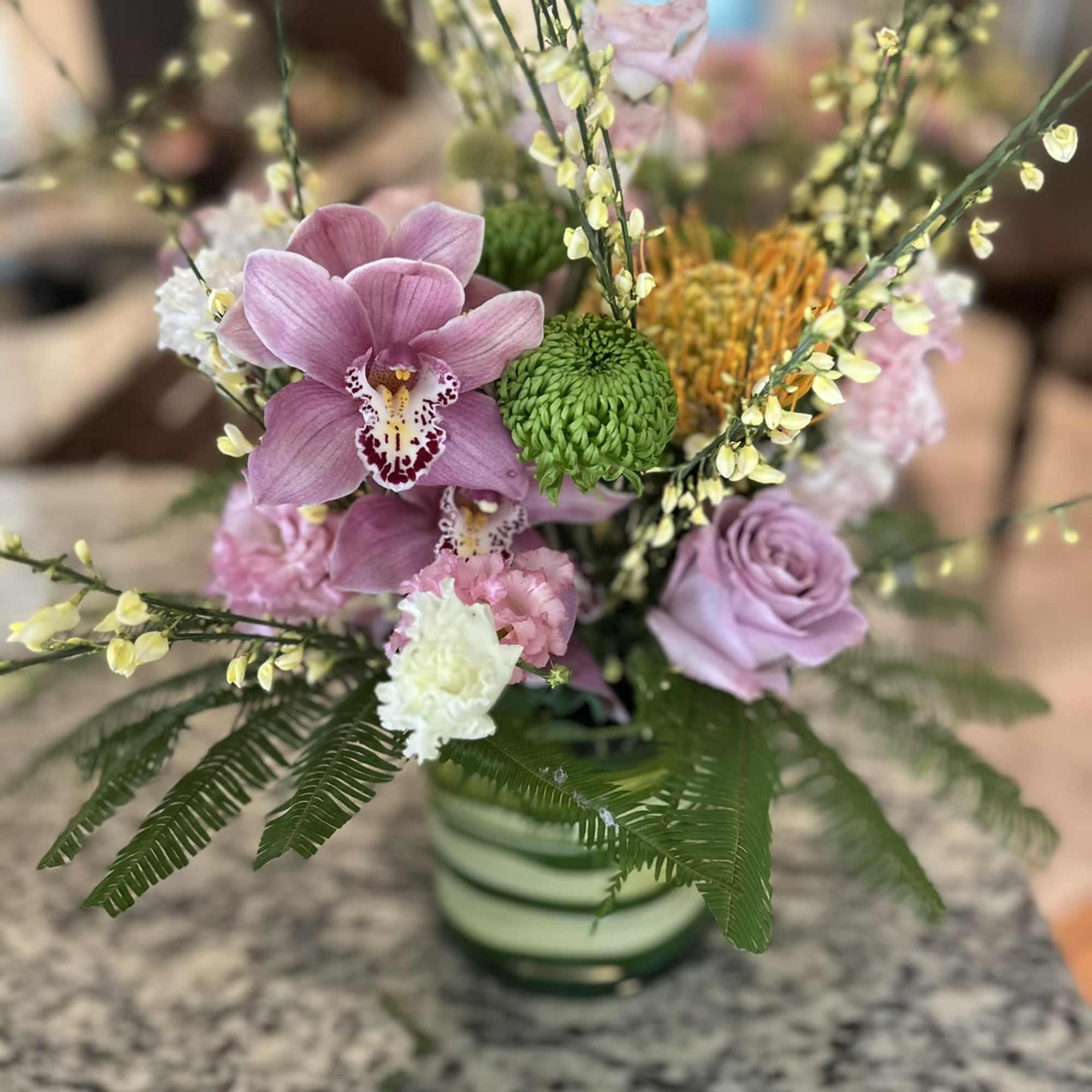 Will be larger than shown12 roses and 2 orchids, plus accent pieces