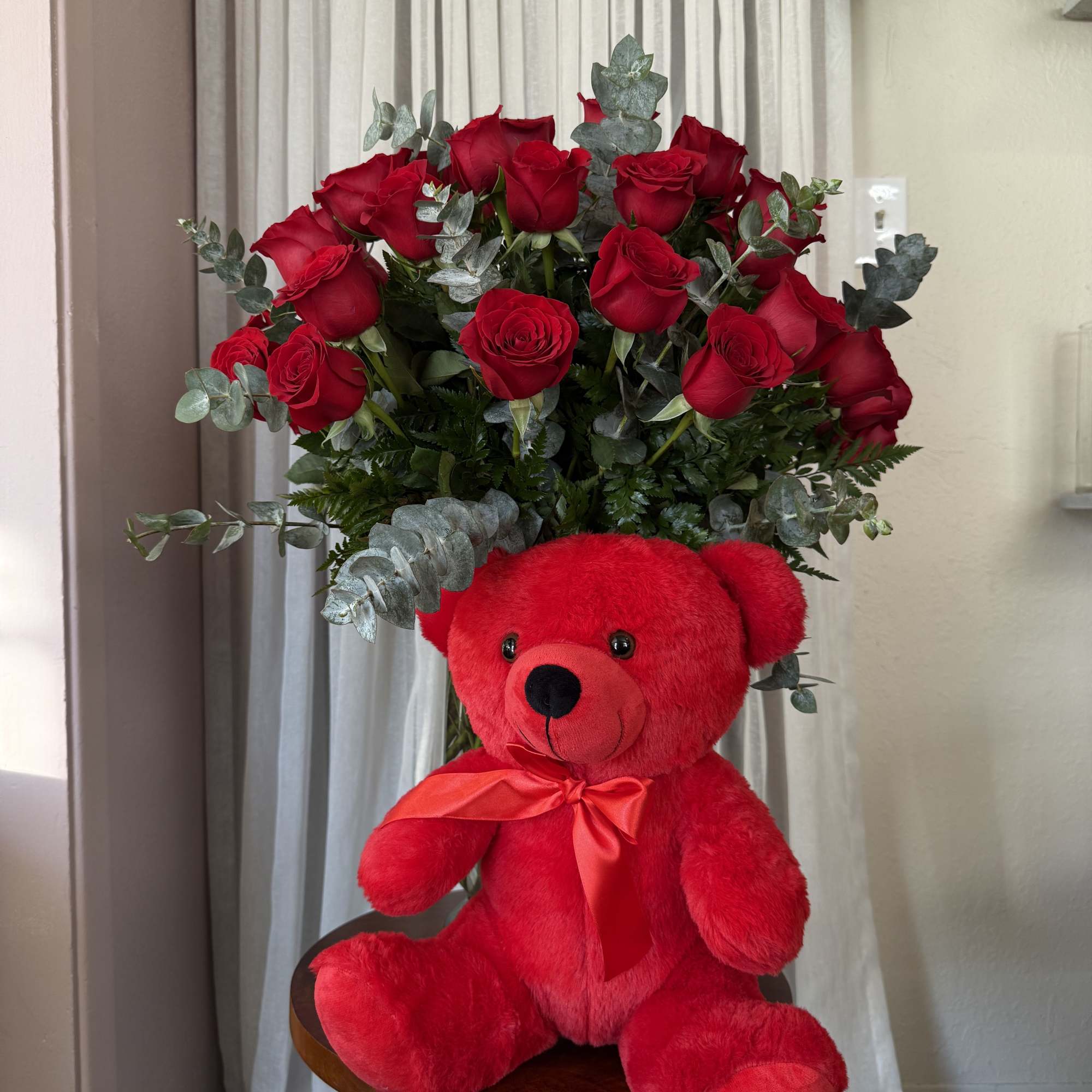 Red rose bouquet with a red teddy bear and satin ribbon