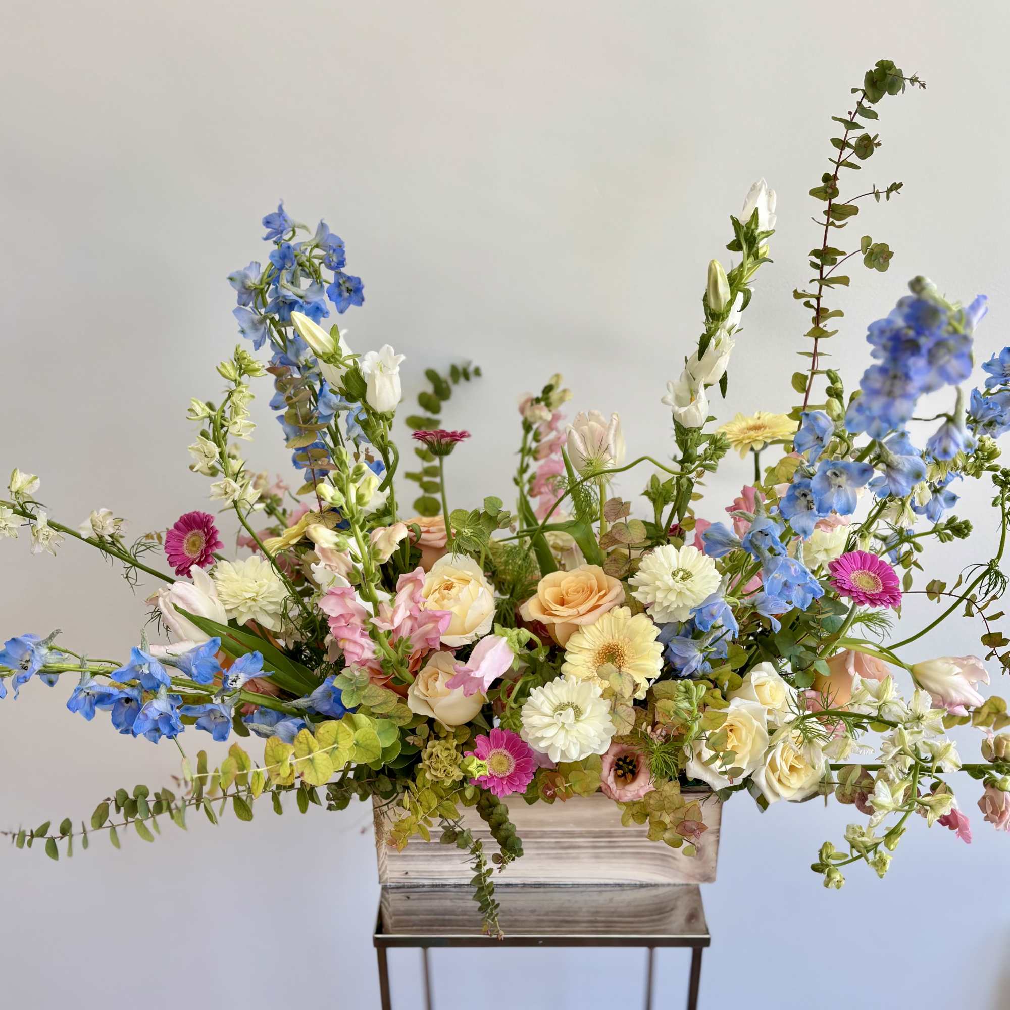 Large mixed flower arrangement in a rectangular wooden container