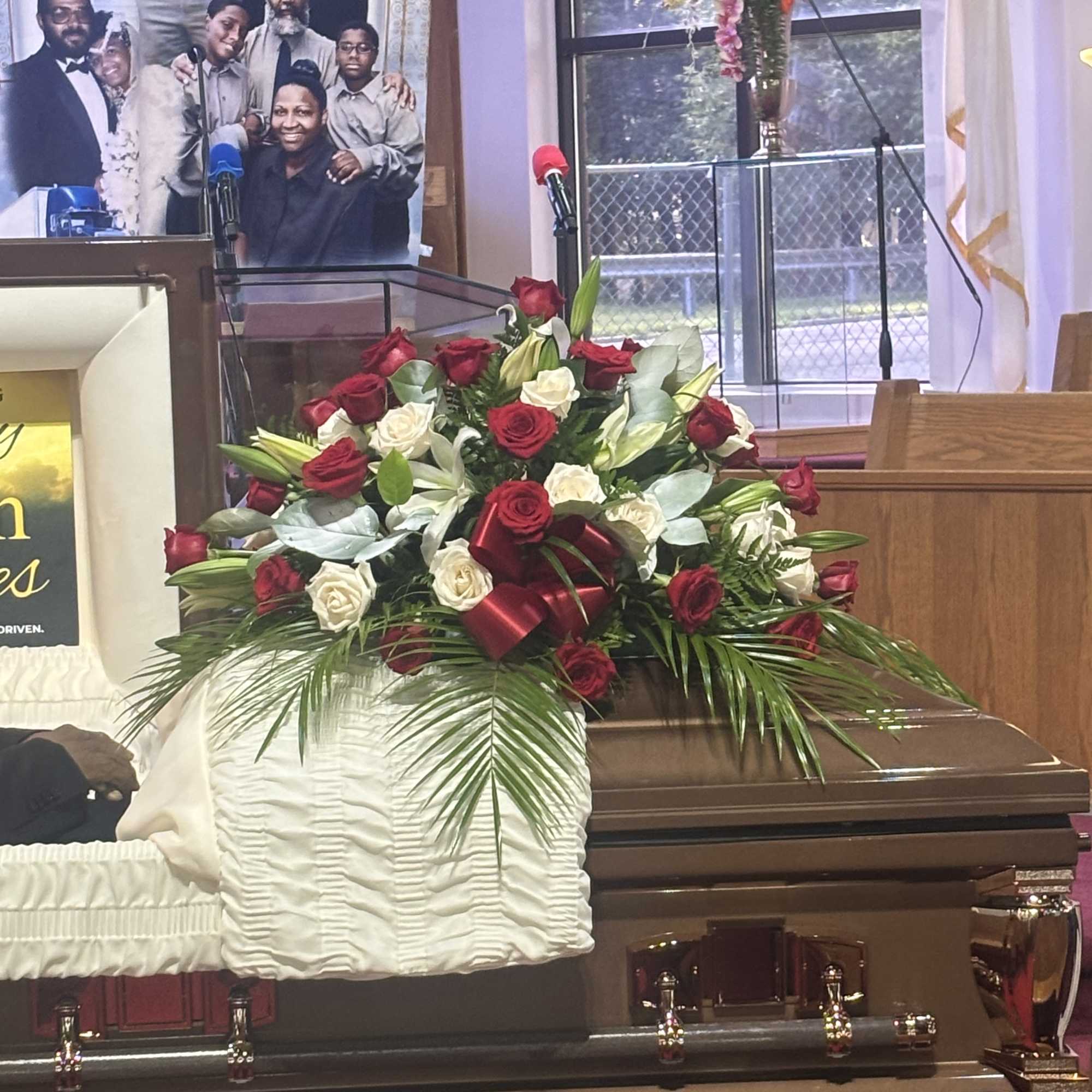 Casket spray of red and white roses with a burgundy ribbon