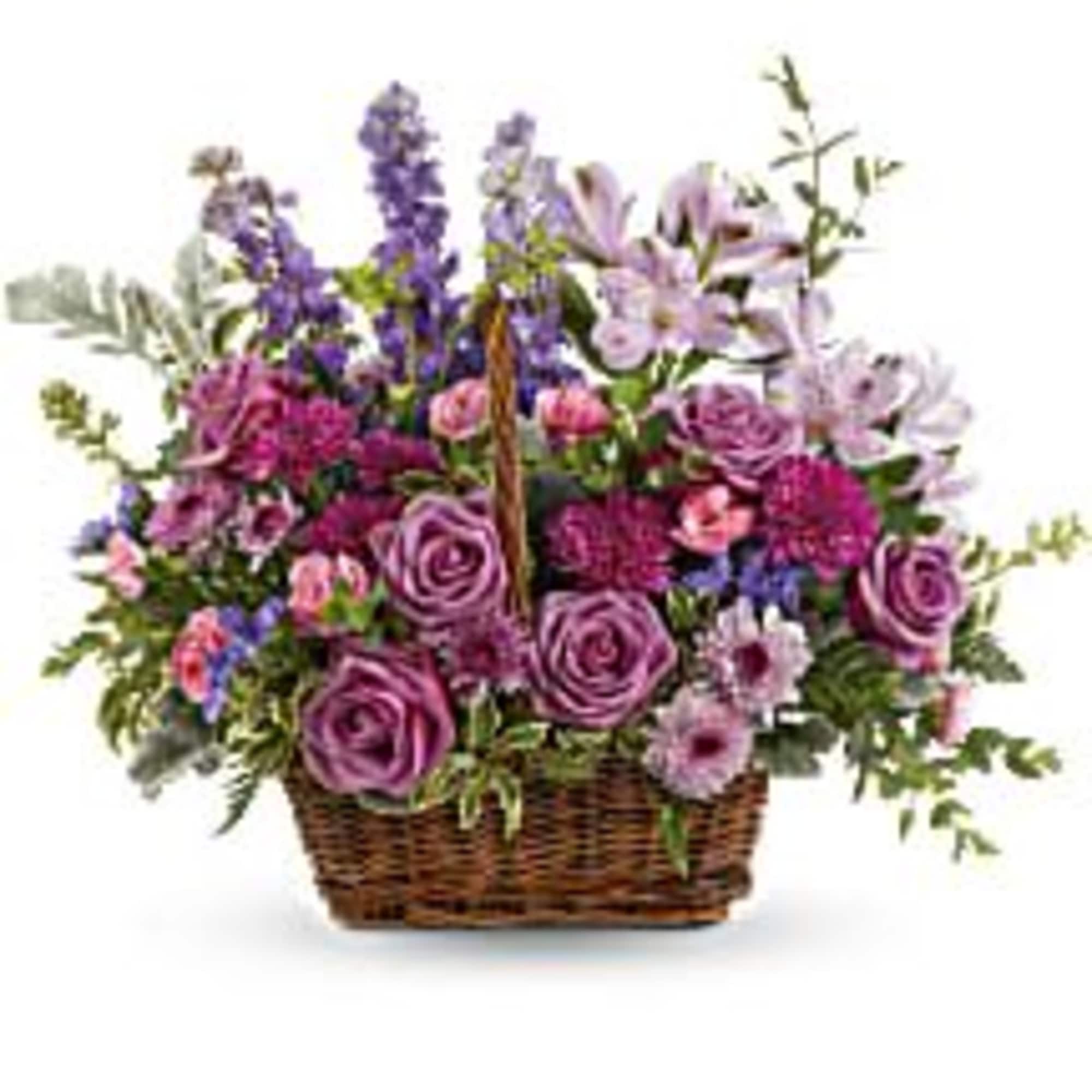 Purple and pink mixed flower basket in a wicker container