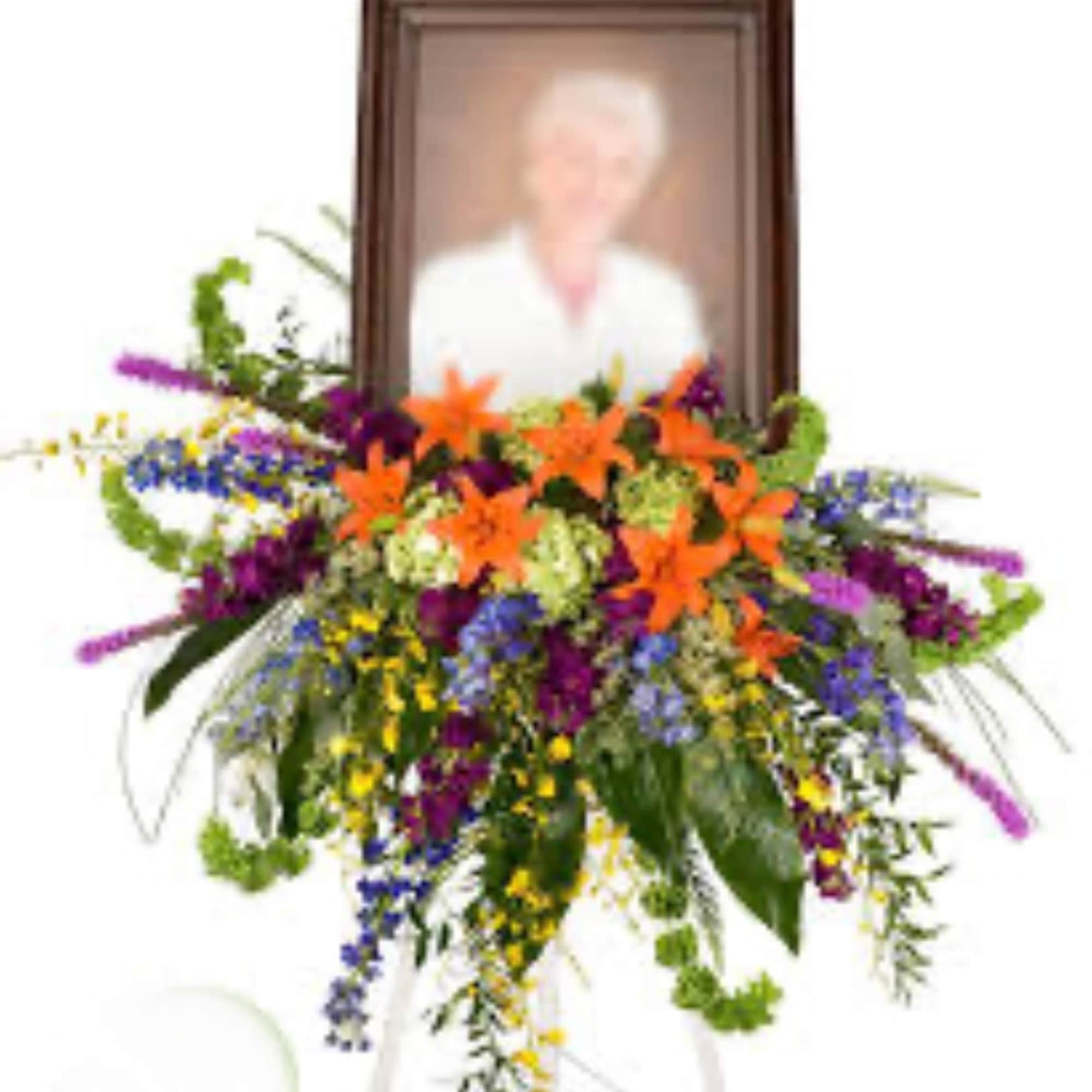Colorful funeral spray with framed portrait on an easel