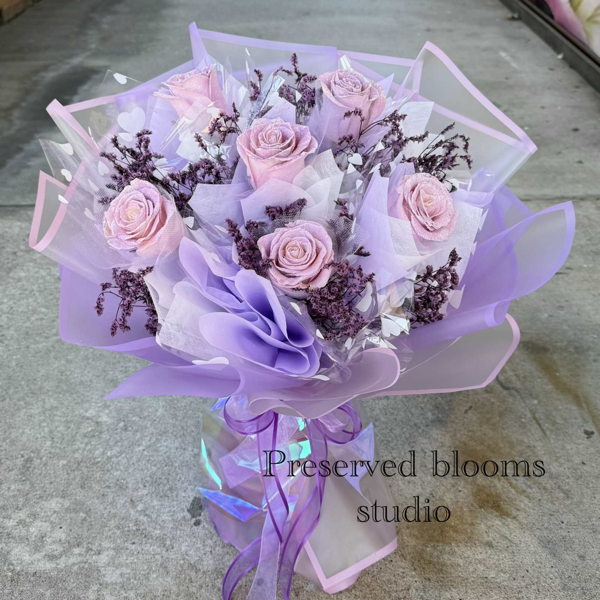 Bouquet of pale pink roses wrapped in lavender paper