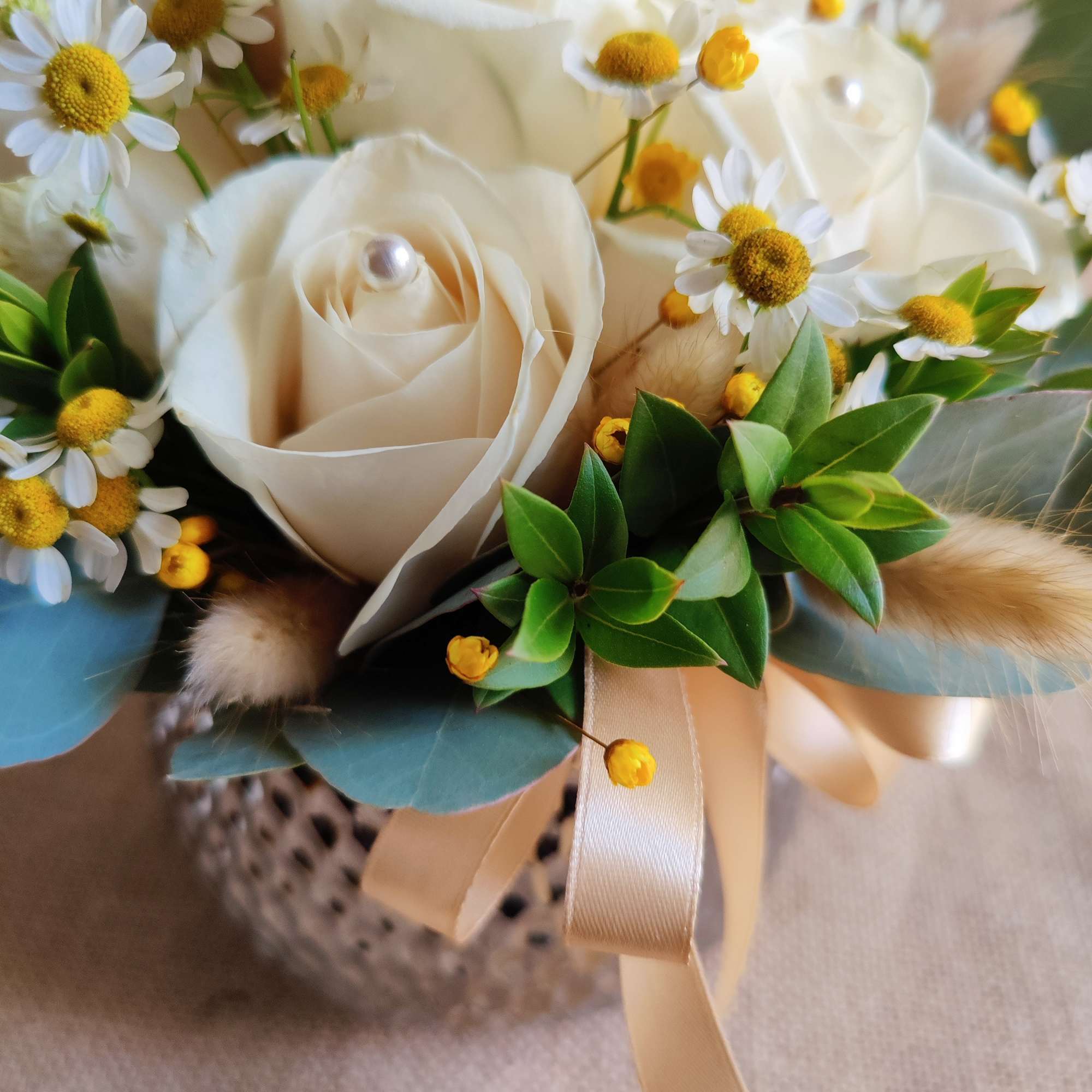 Bouquet of white roses and small daisy flowers with a satin ribbon