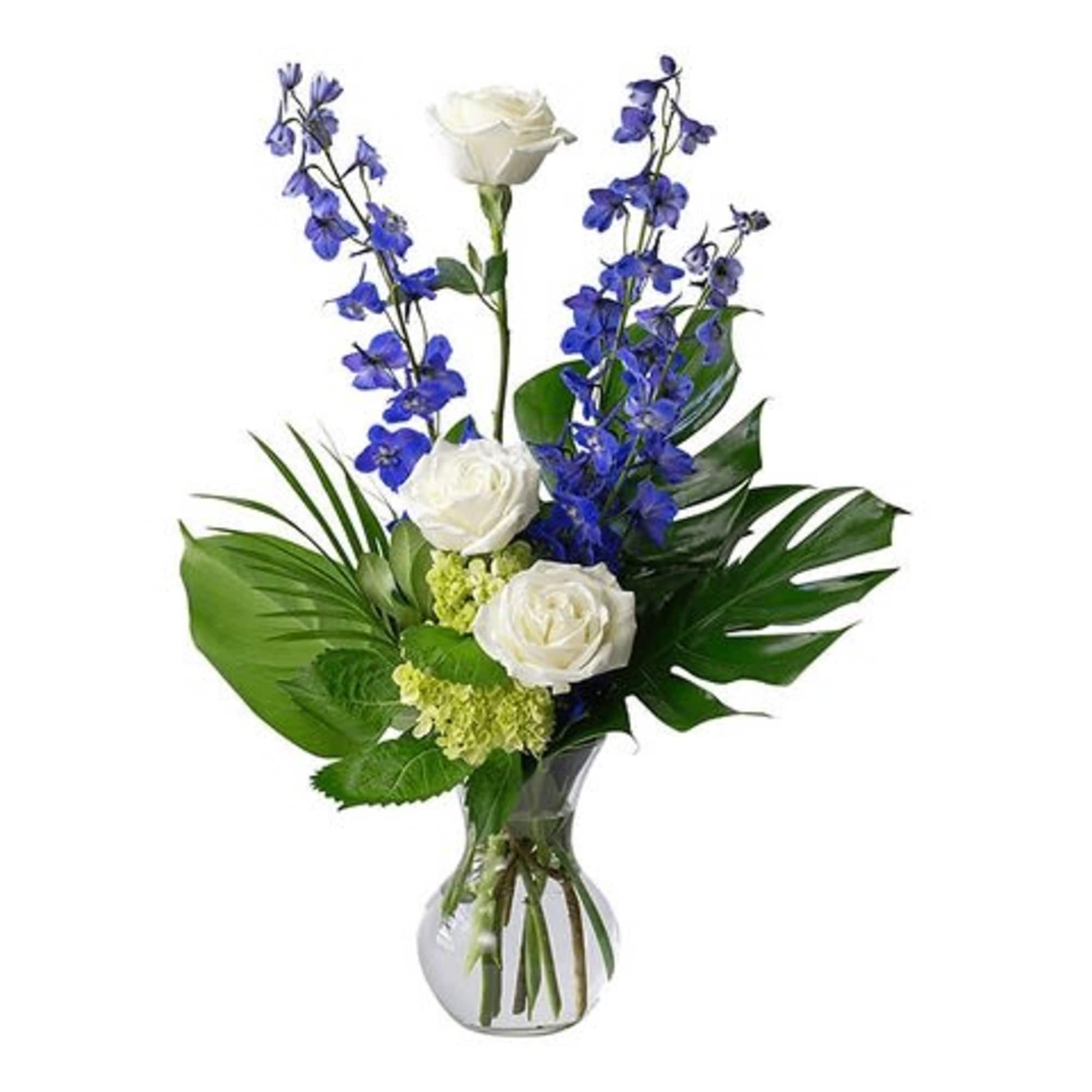 White roses and blue flowers arranged in a glass vase
