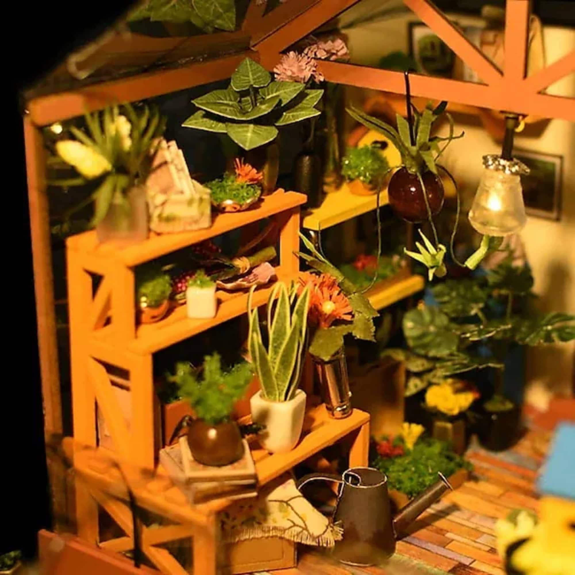 Miniature plant display on orange shelves with small potted flowers and decor