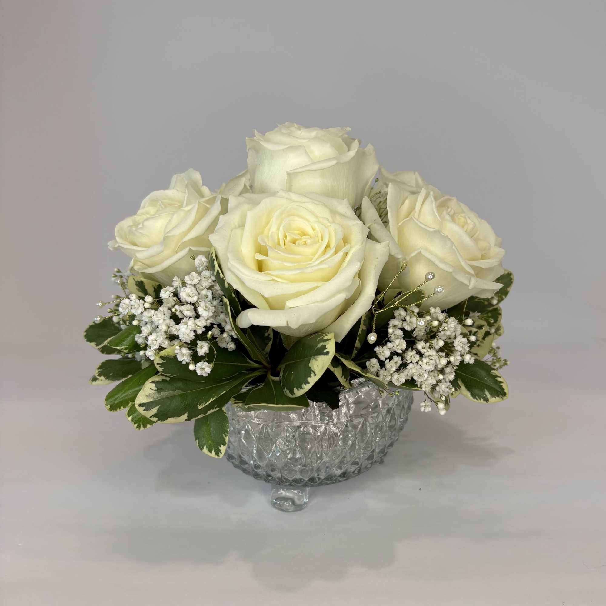 Featuring white roses, this small centerpiece accentuates a variety of special occasions.