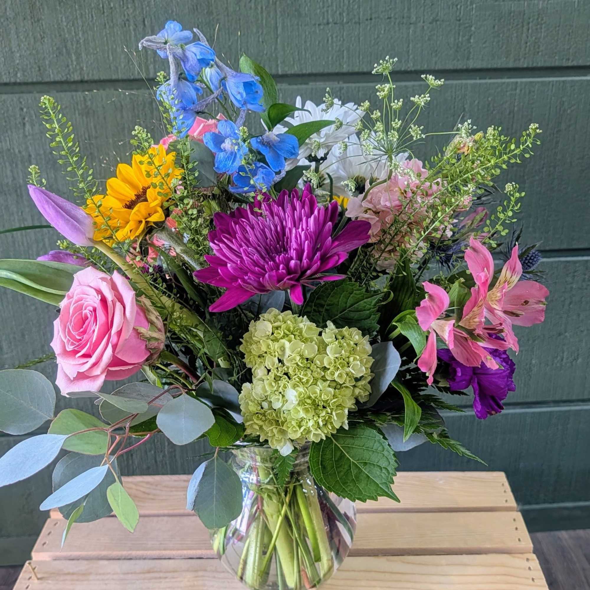 Summer Glow pairs sunflowers and pink roses with vivid purple chrysanthemums and