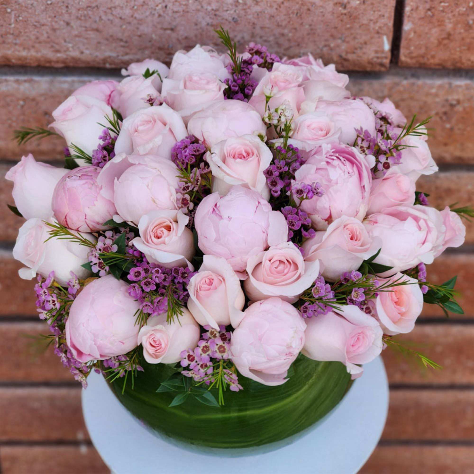 Bouquet of pale pink roses and peonies with purple filler flowers