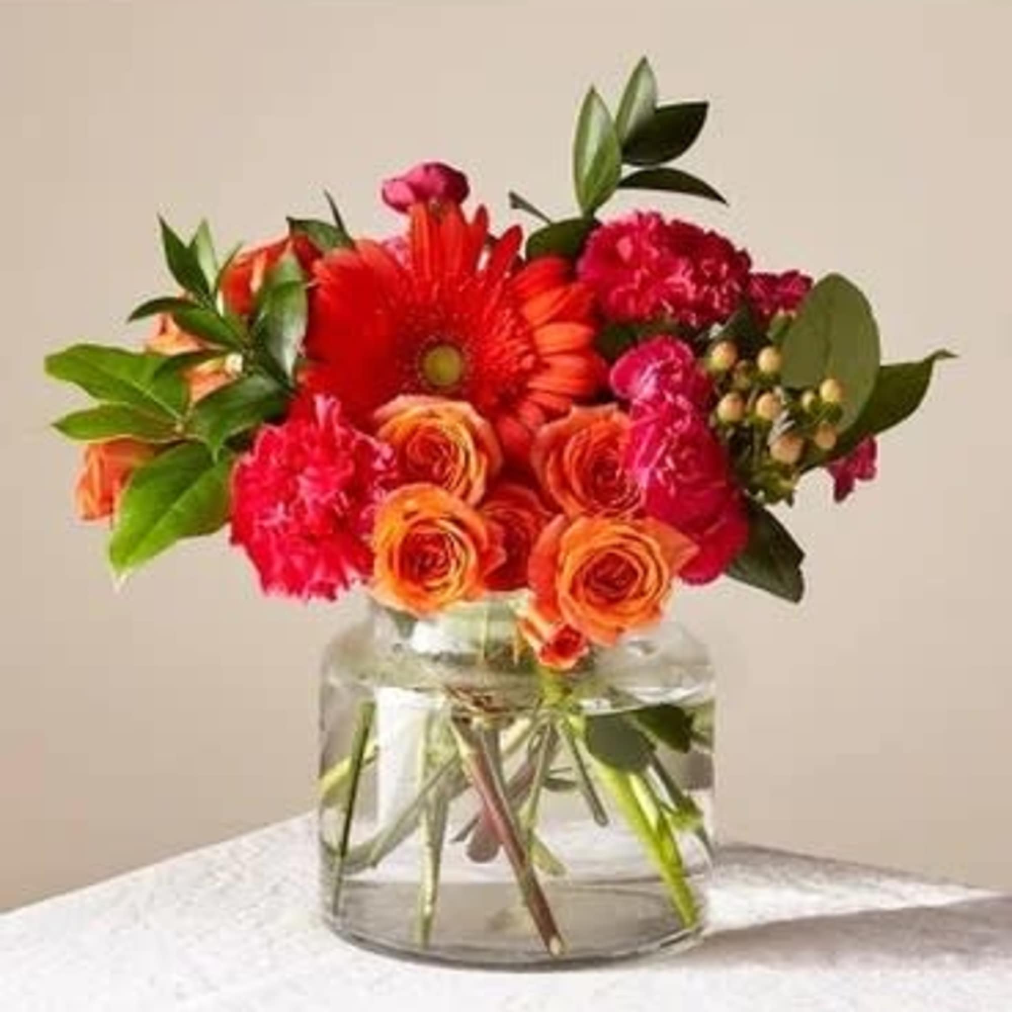 Bouquet of red and orange flowers in a clear glass vase