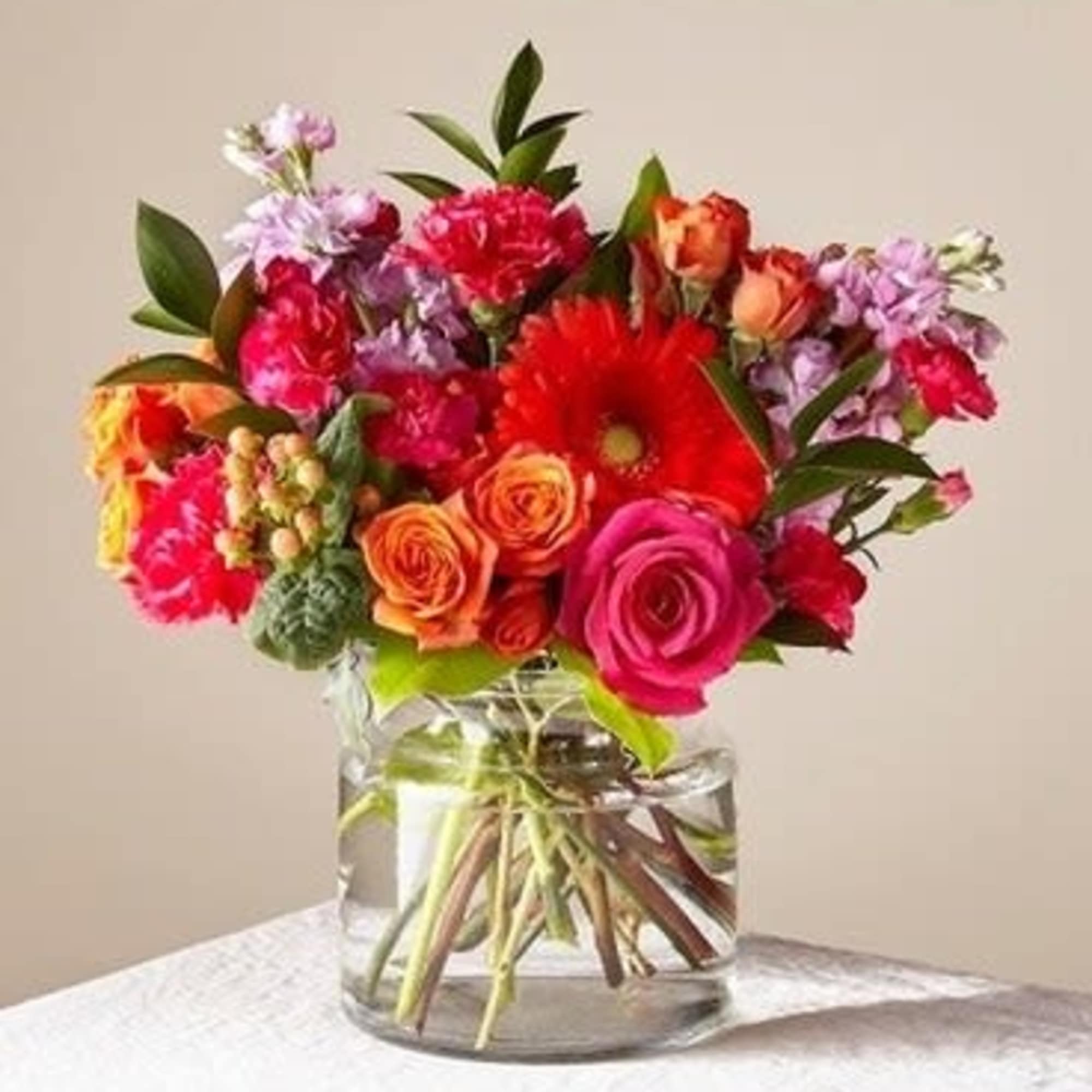 Mixed bouquet of bright flowers in a clear glass vase
