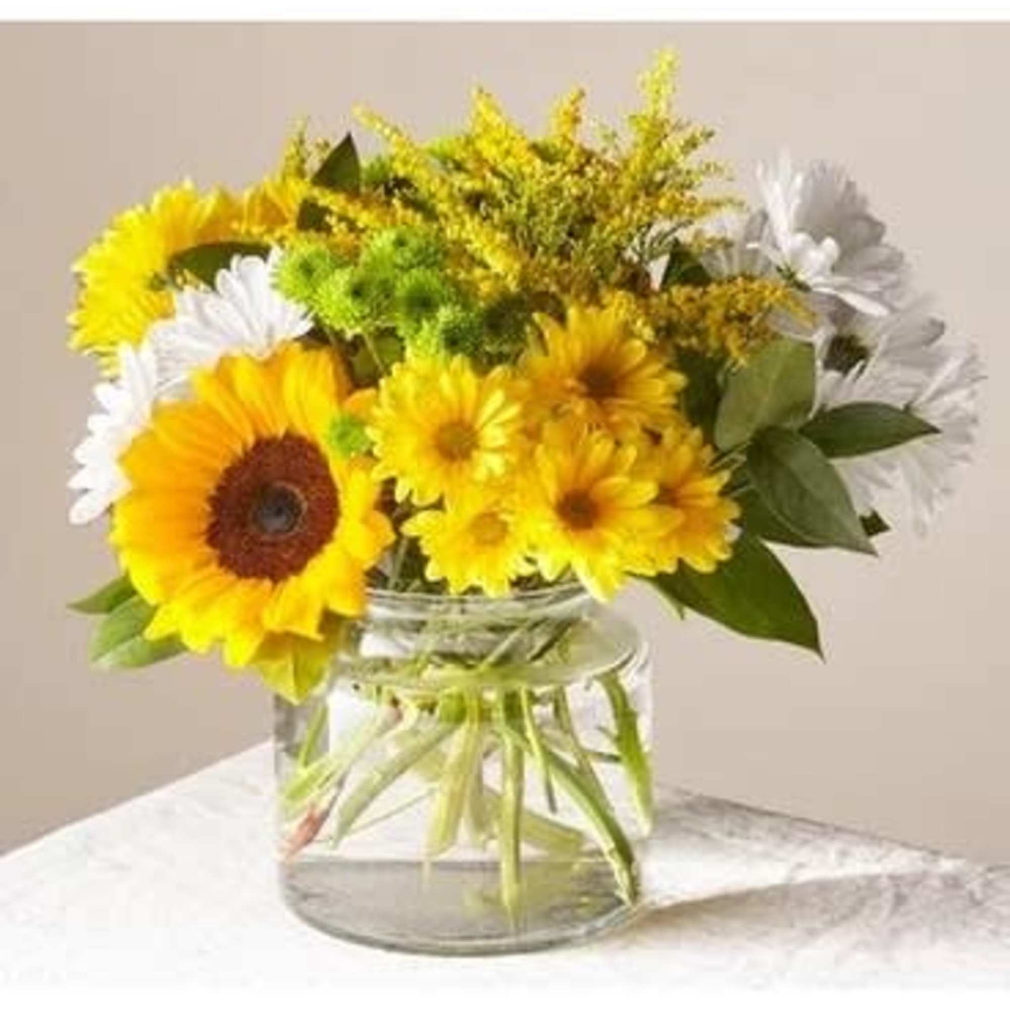 Sunflowers and white daisies in a clear glass vase