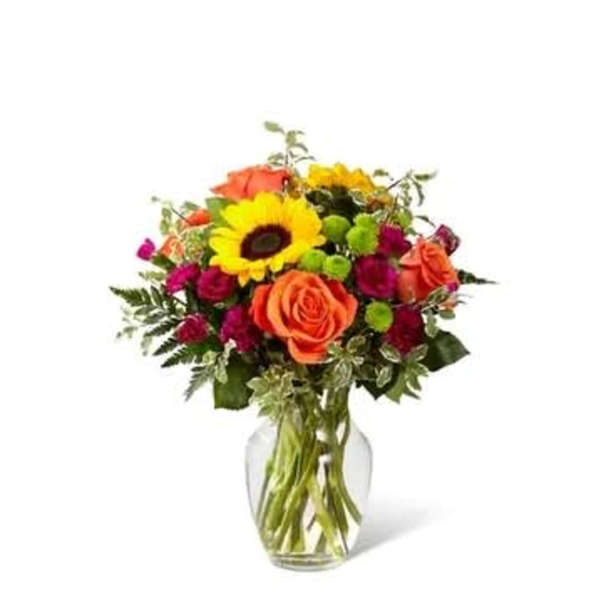 Bouquet of orange roses and a yellow sunflower in a glass vase