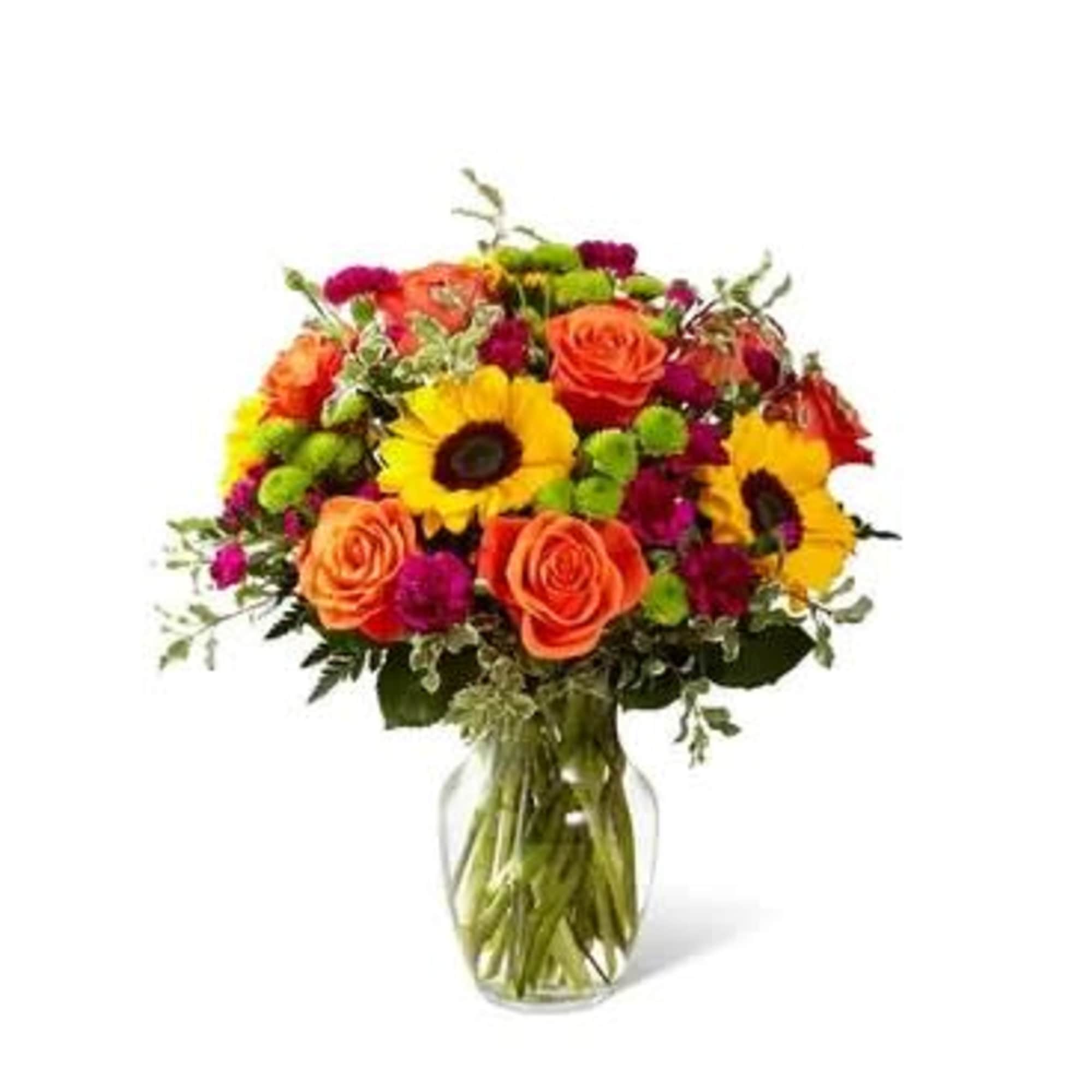 Mixed bouquet of orange roses and yellow sunflowers in a glass vase