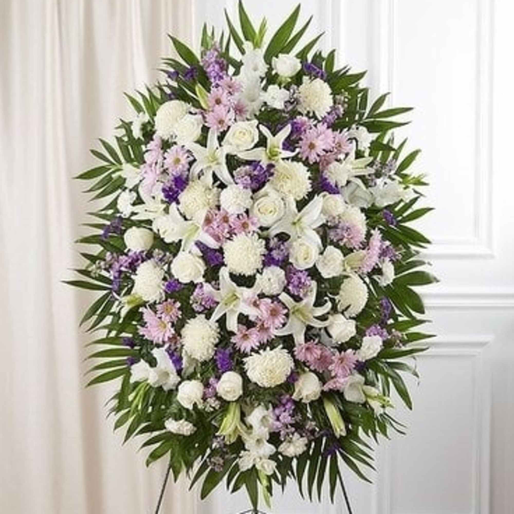 Large white and purple funeral spray on a stand