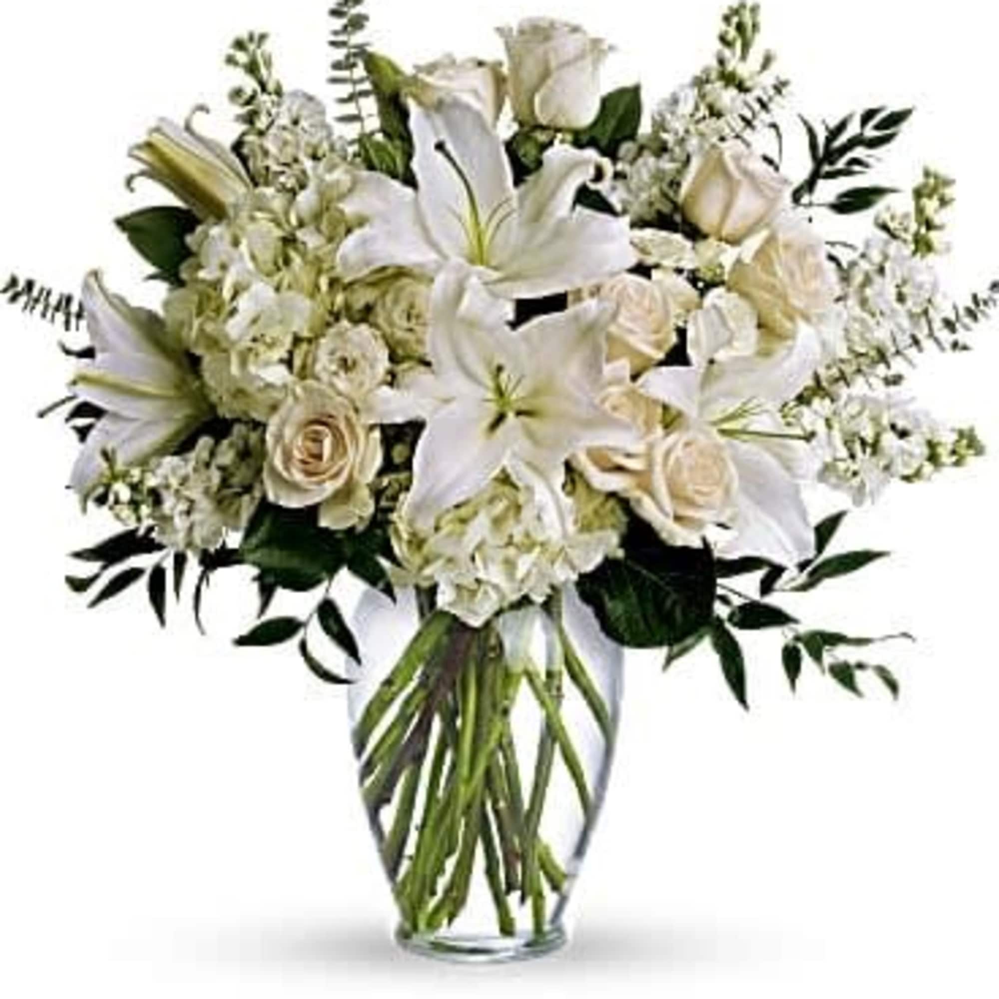 White lilies and roses in a clear glass vase