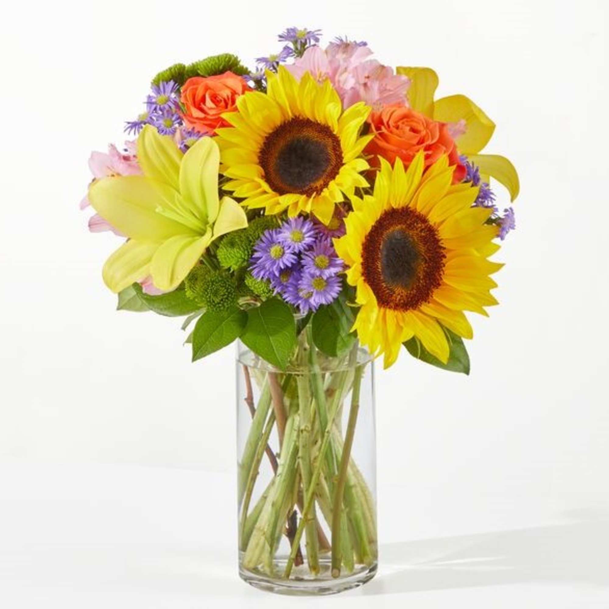 Sunflowers and mixed flowers in a clear glass vase