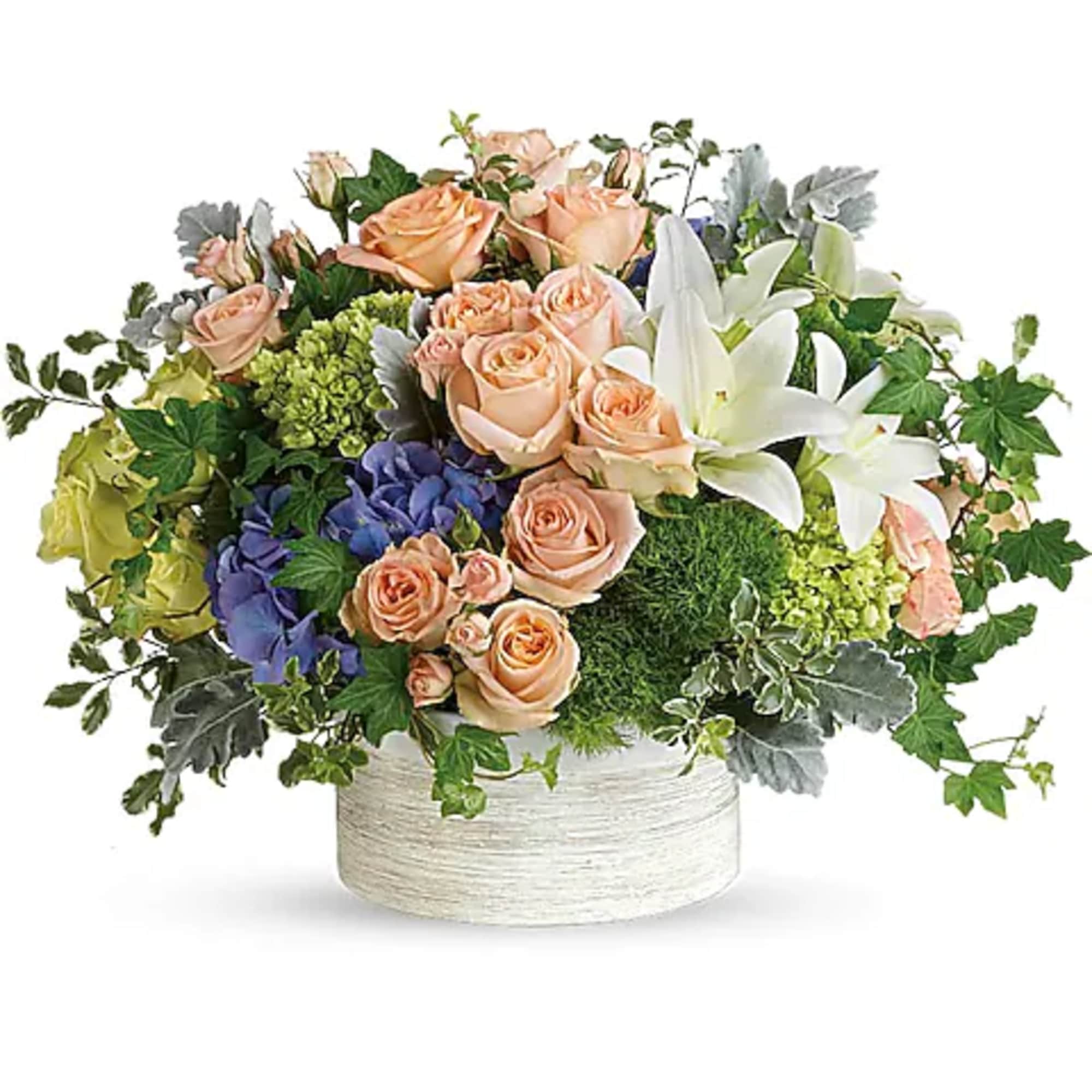 Peach roses and white lilies in a low white container