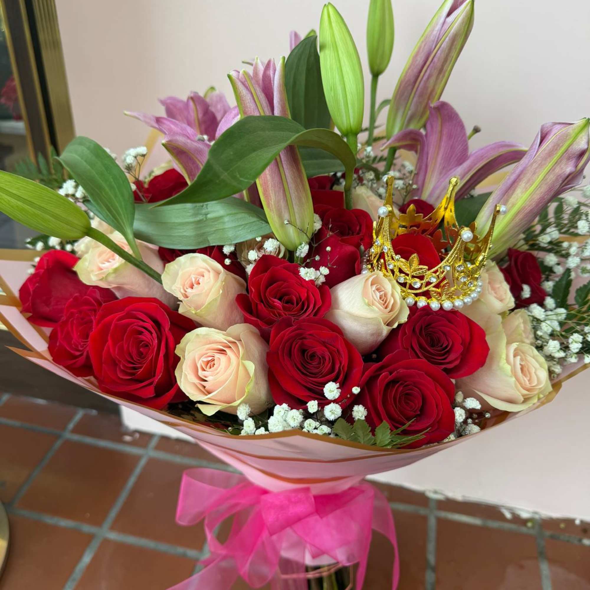 Bouquet of red and blush roses with pink lilies and a pink ribbon