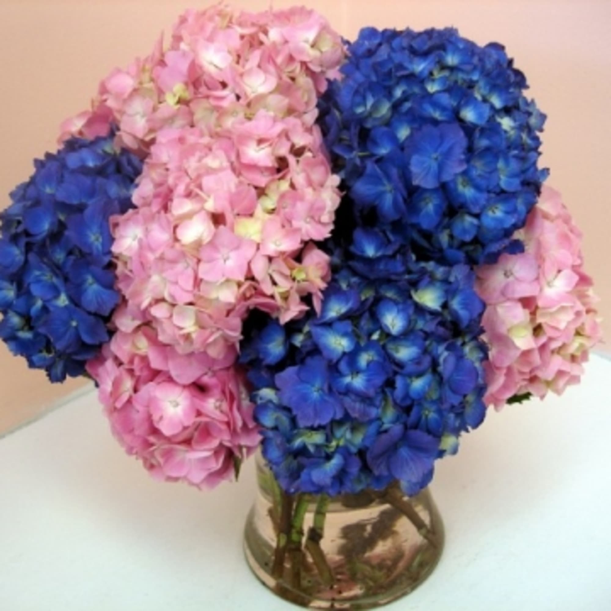 Pink and blue hydrangea bouquet in a glass vase