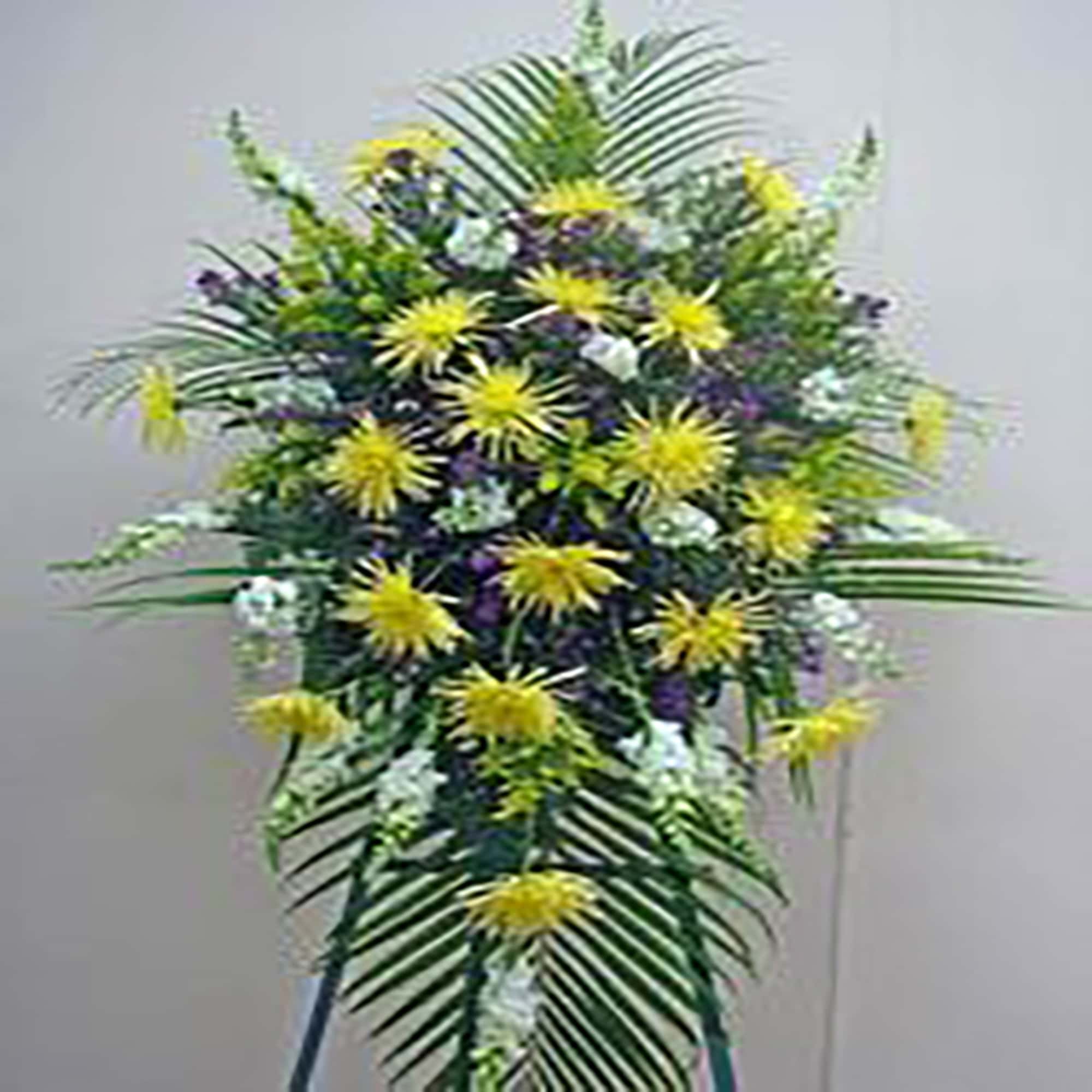 Tall standing spray with yellow chrysanthemums, white flowers, and purple accents on palm fronds.