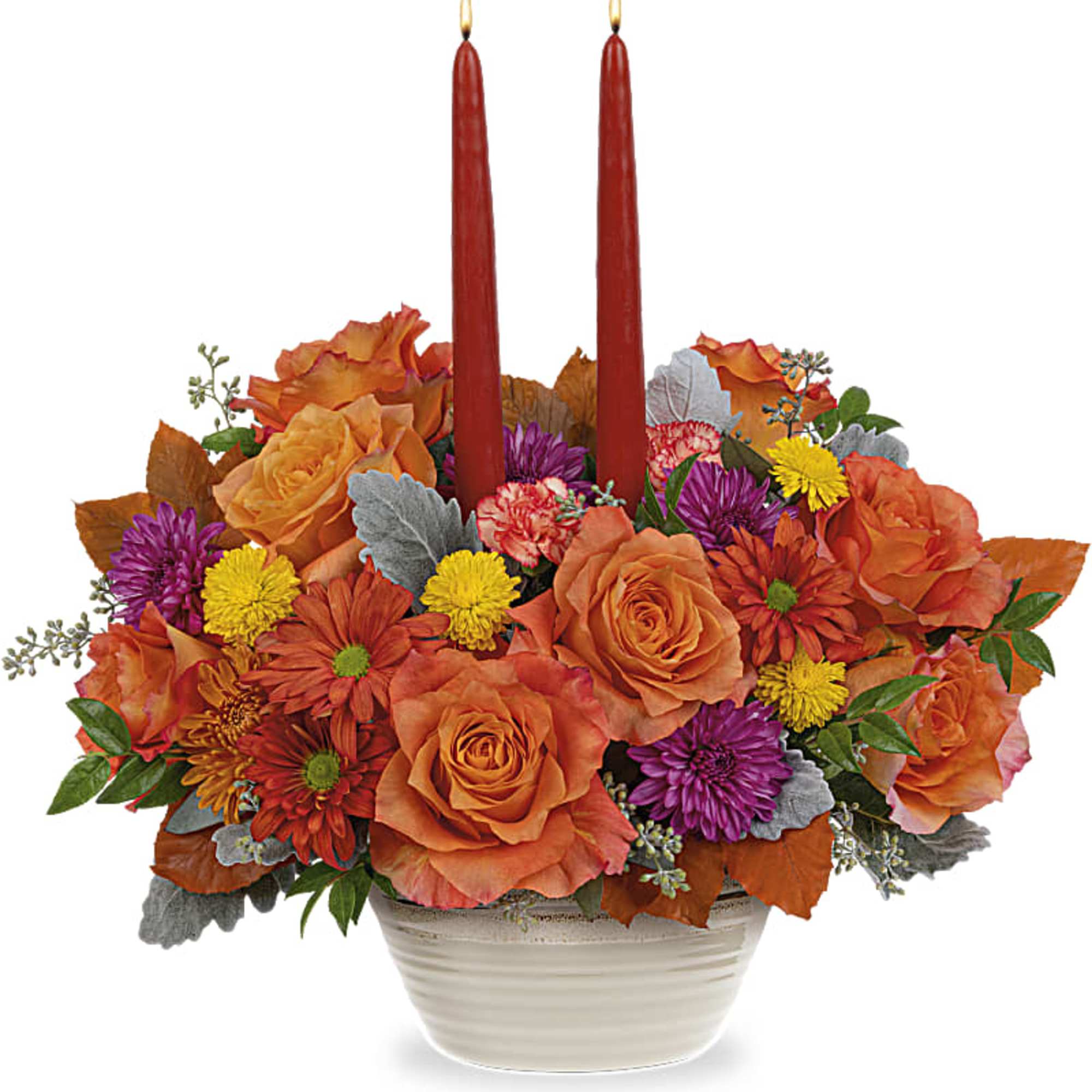 Orange and purple floral centerpiece with two red candles in a white bowl vase
