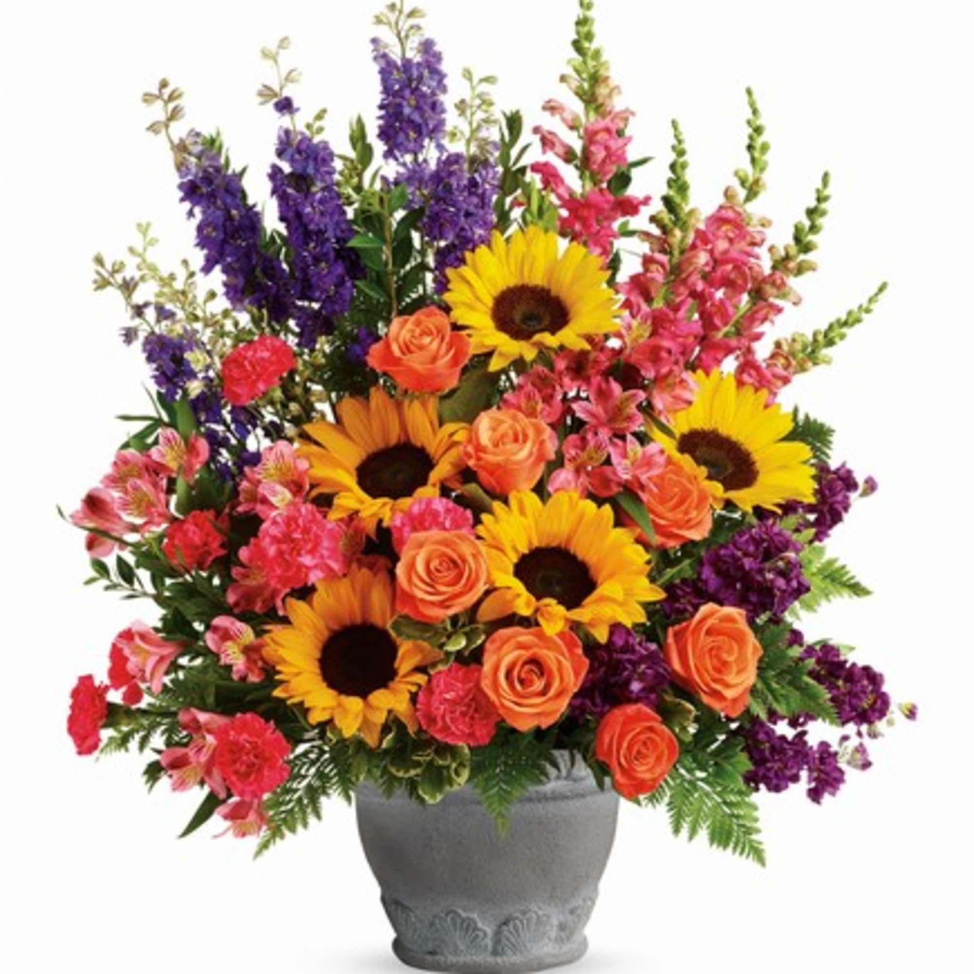 Colorful bouquet of sunflowers, roses, and purple spikes in a gray vase