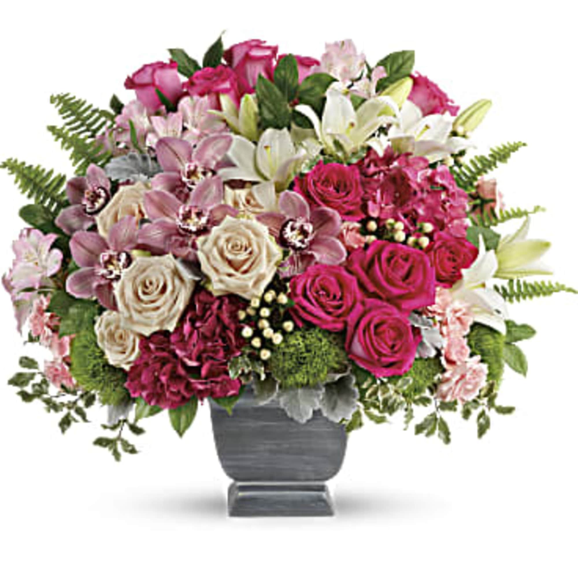 Mixed pink and white flower arrangement in a gray urn vase