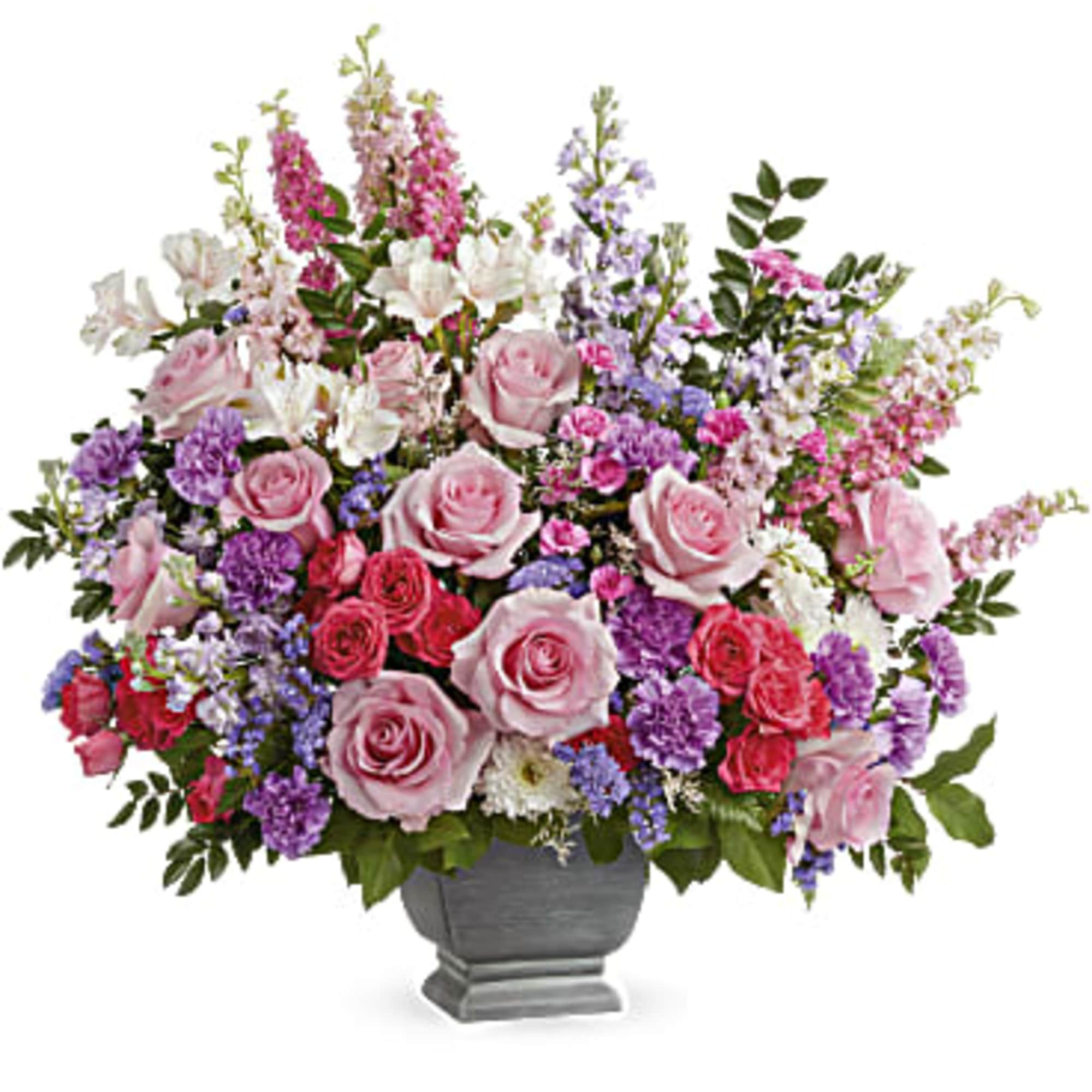 Pink and purple rose arrangement in a gray urn vase
