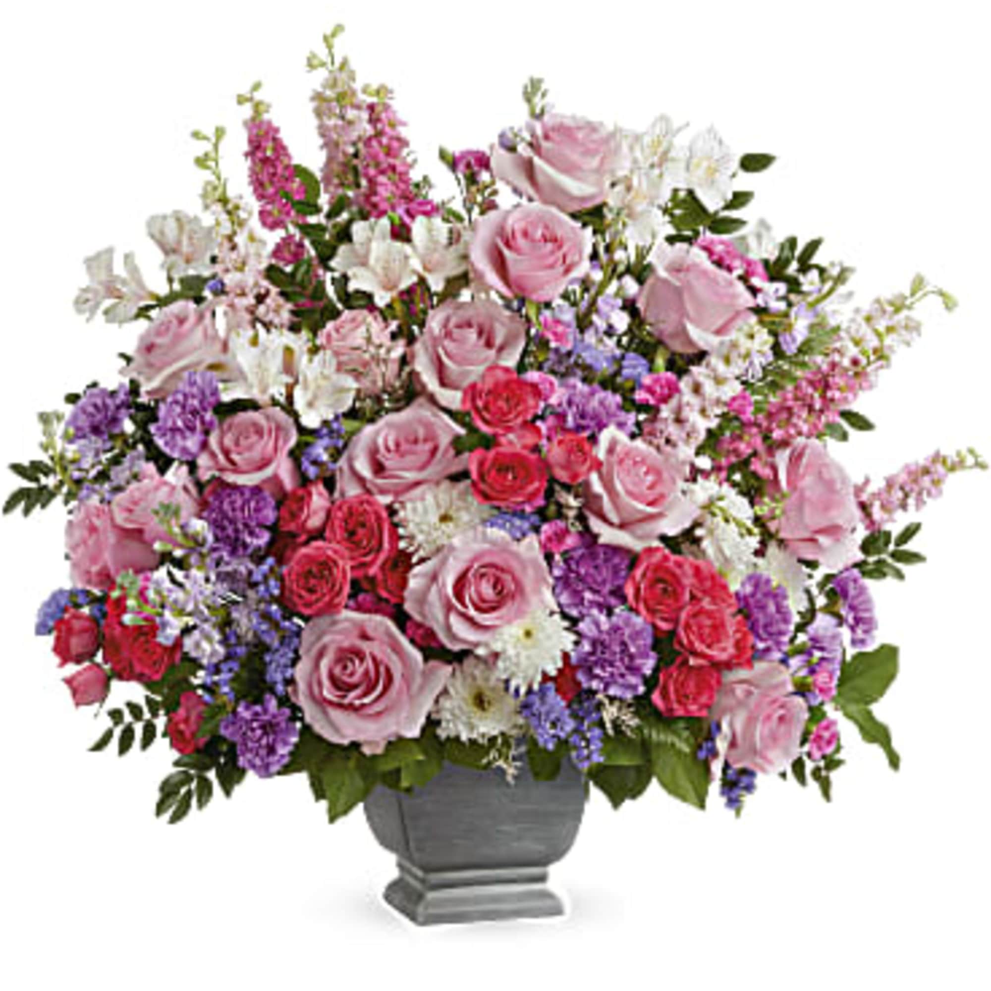 Large mixed bouquet of pink and purple flowers in a gray urn vase