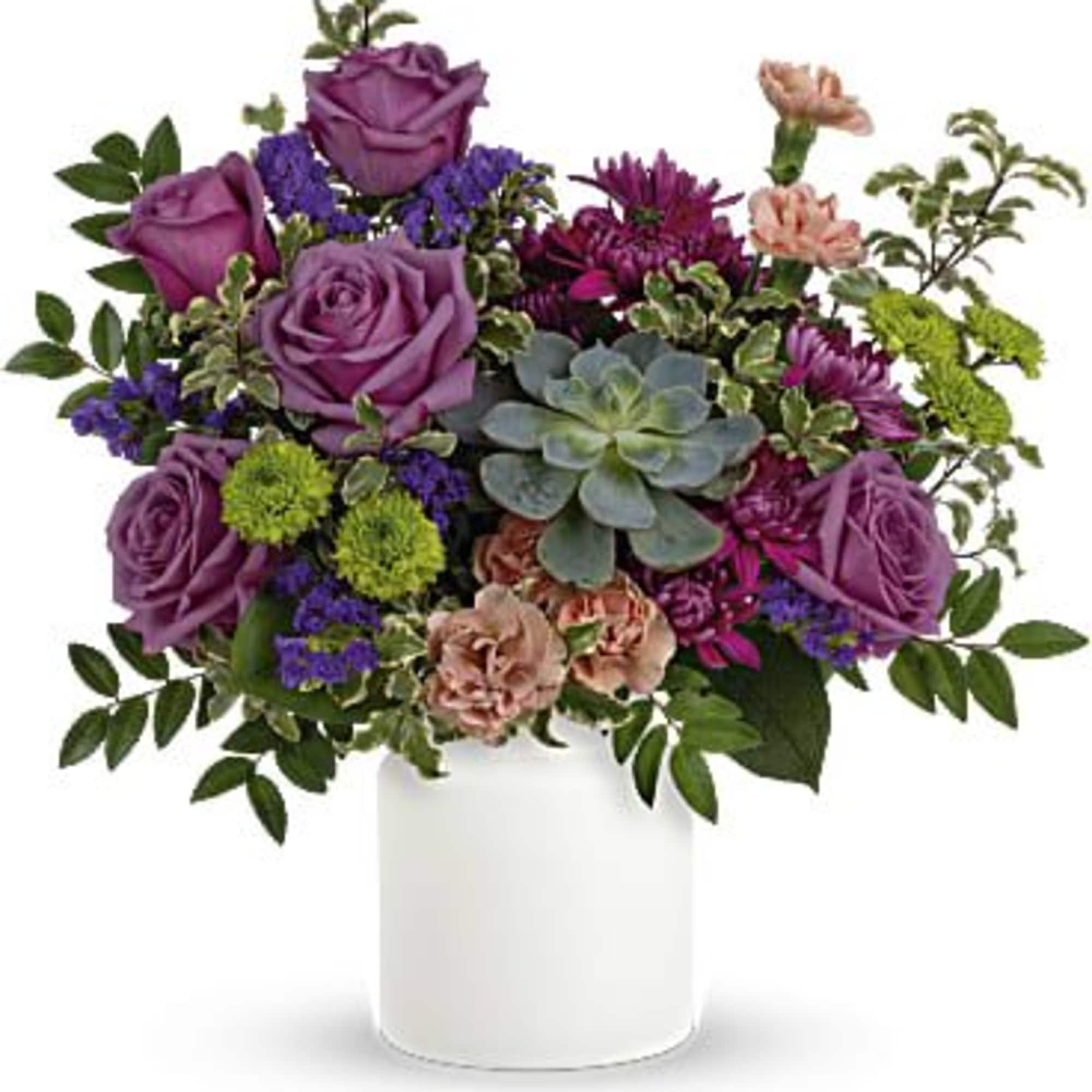 Purple roses and mixed flowers arranged in a white vase