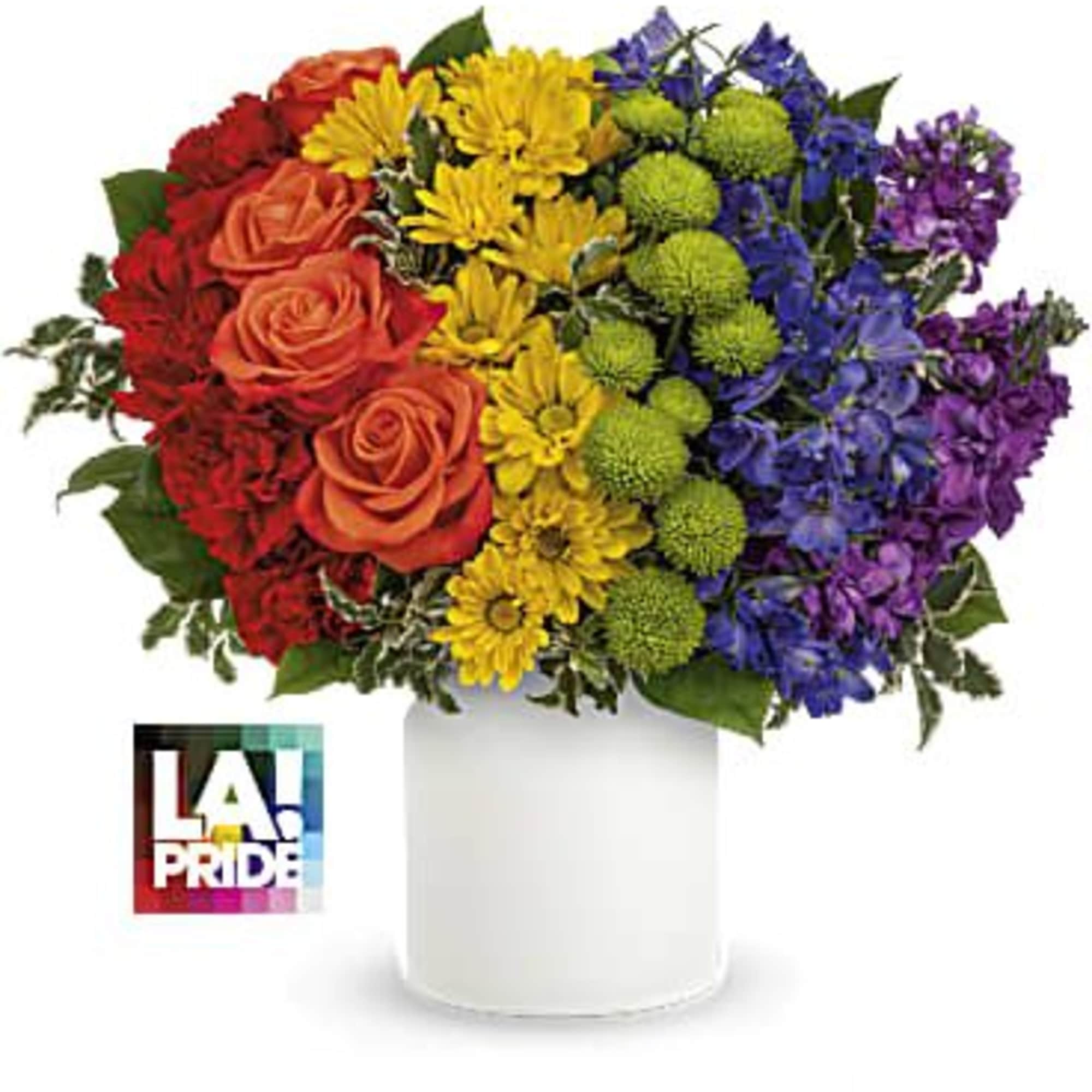 Rainbow bouquet of roses, daisies, and mums in a white vase