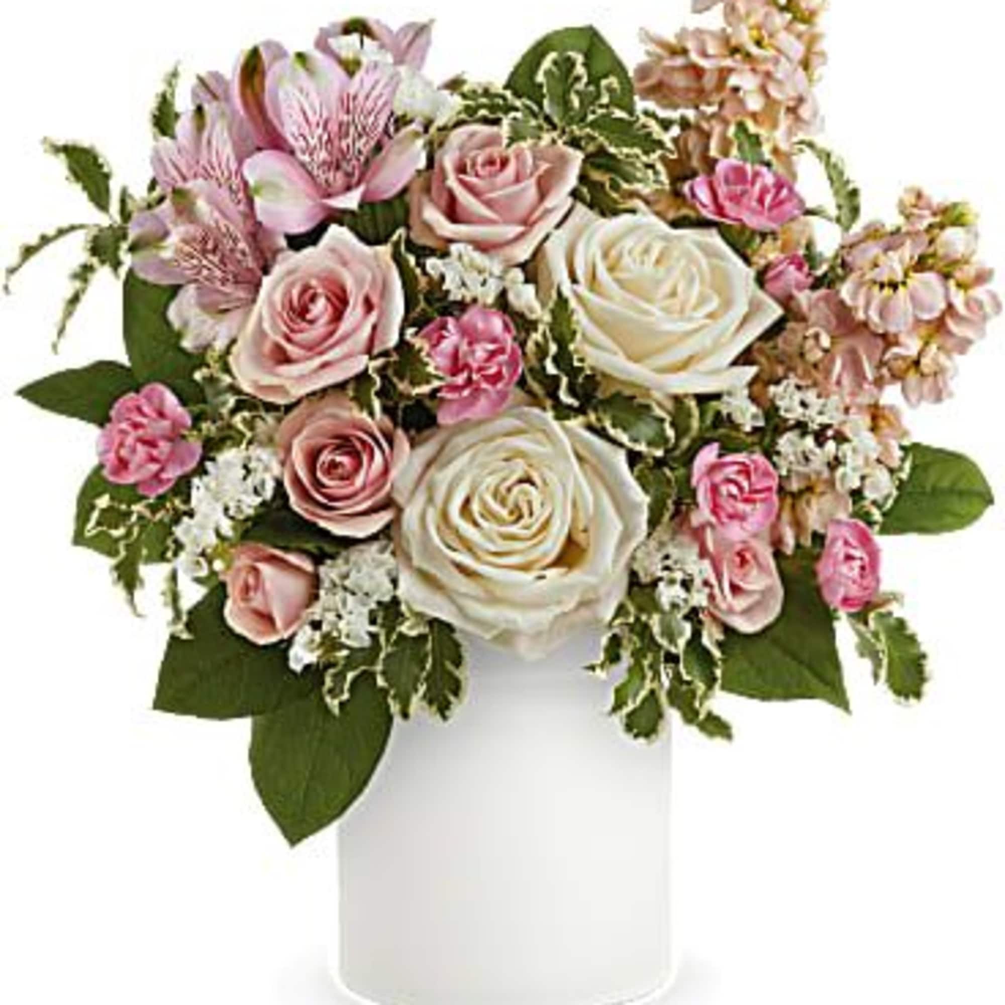Pink and white roses in a white vase with mixed filler flowers