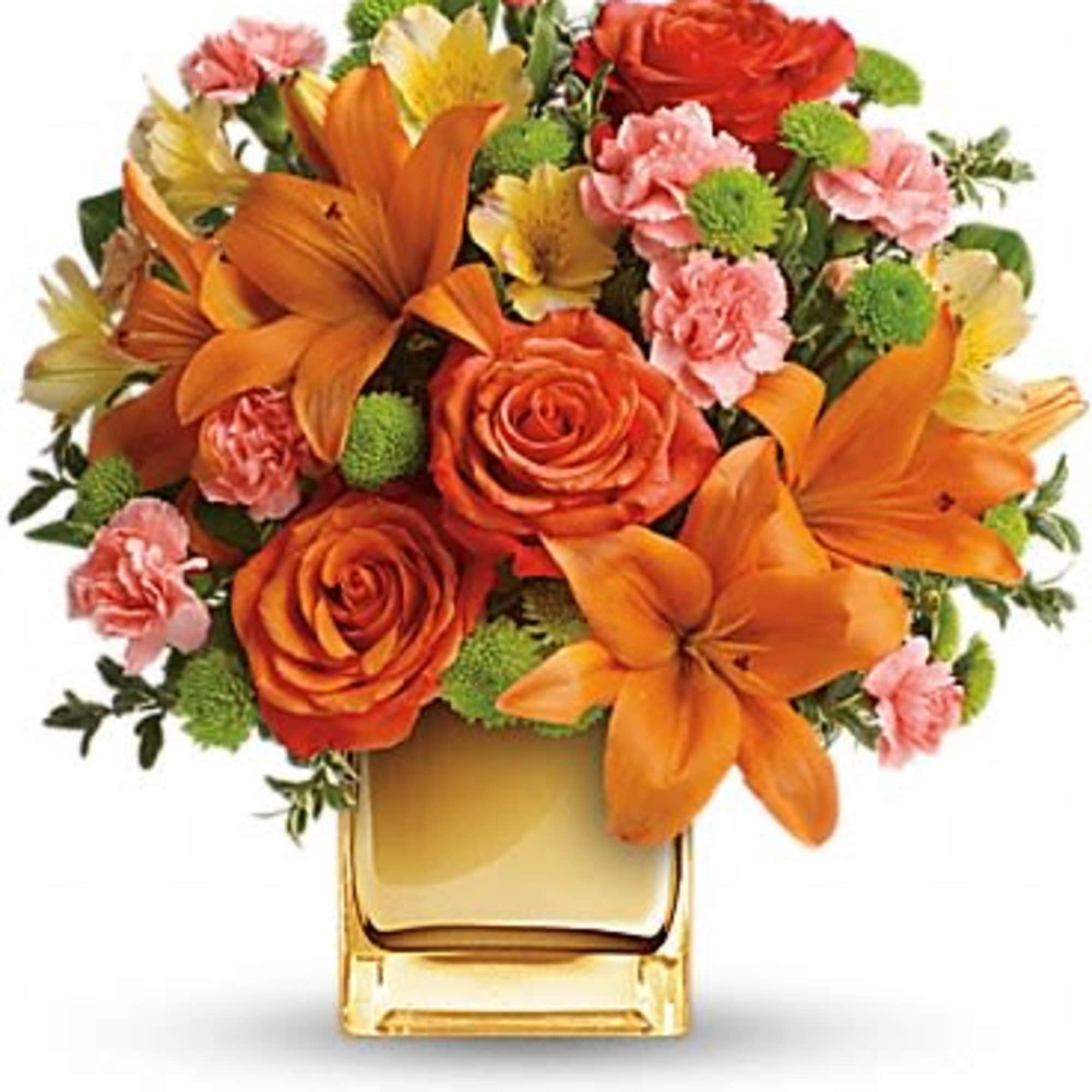 Orange lilies and roses in a square glass vase