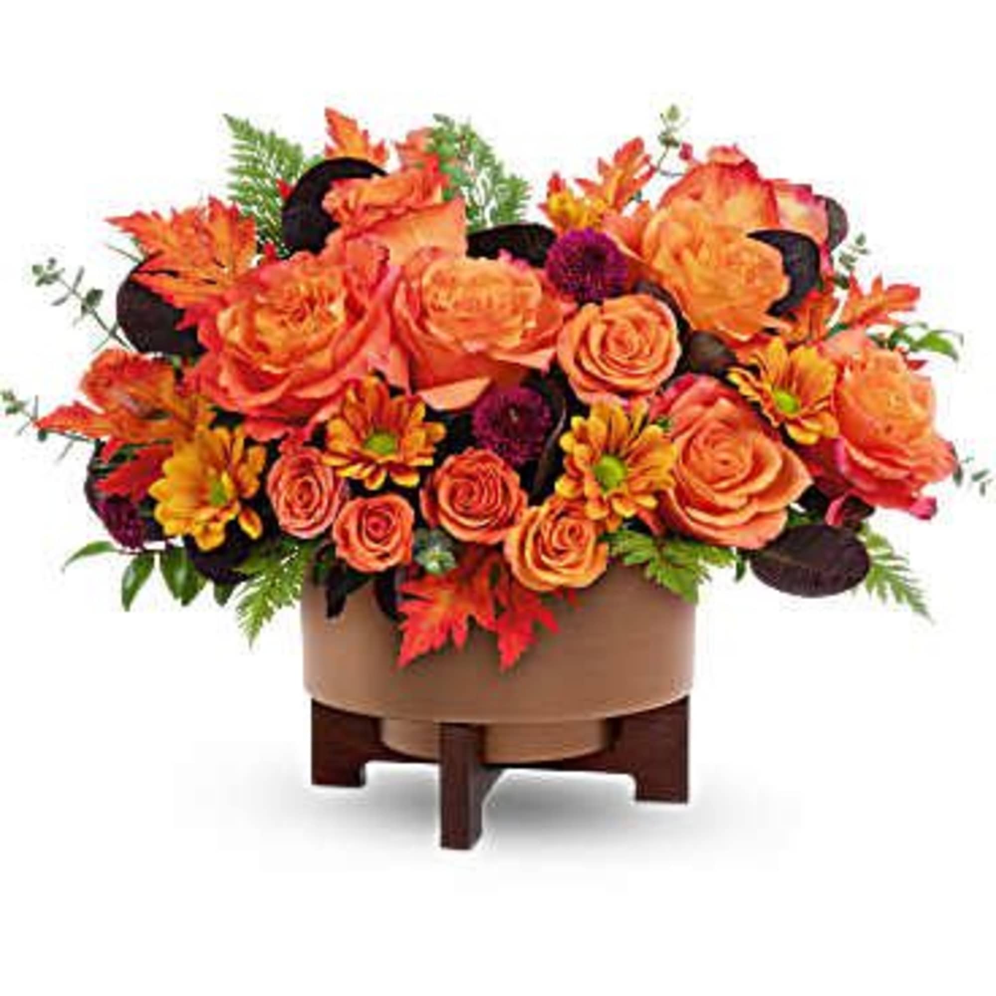 Orange roses and autumn flowers arranged in a low wooden container