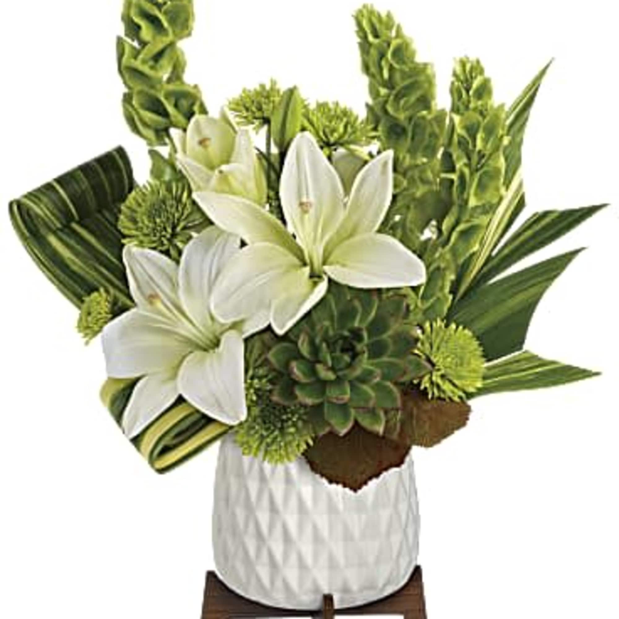 White lilies and green tropical flowers in a white vase