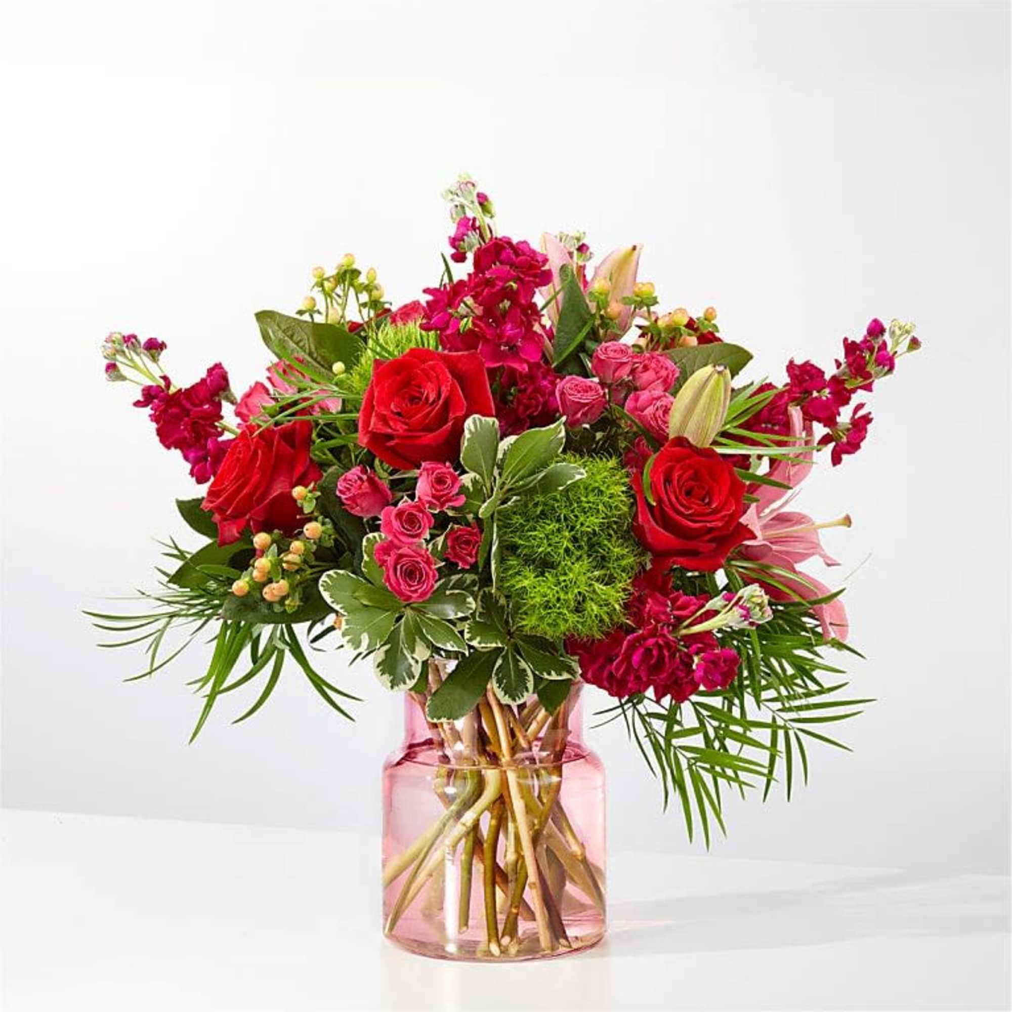 A lush bouquet of red and pink roses paired with pale pink