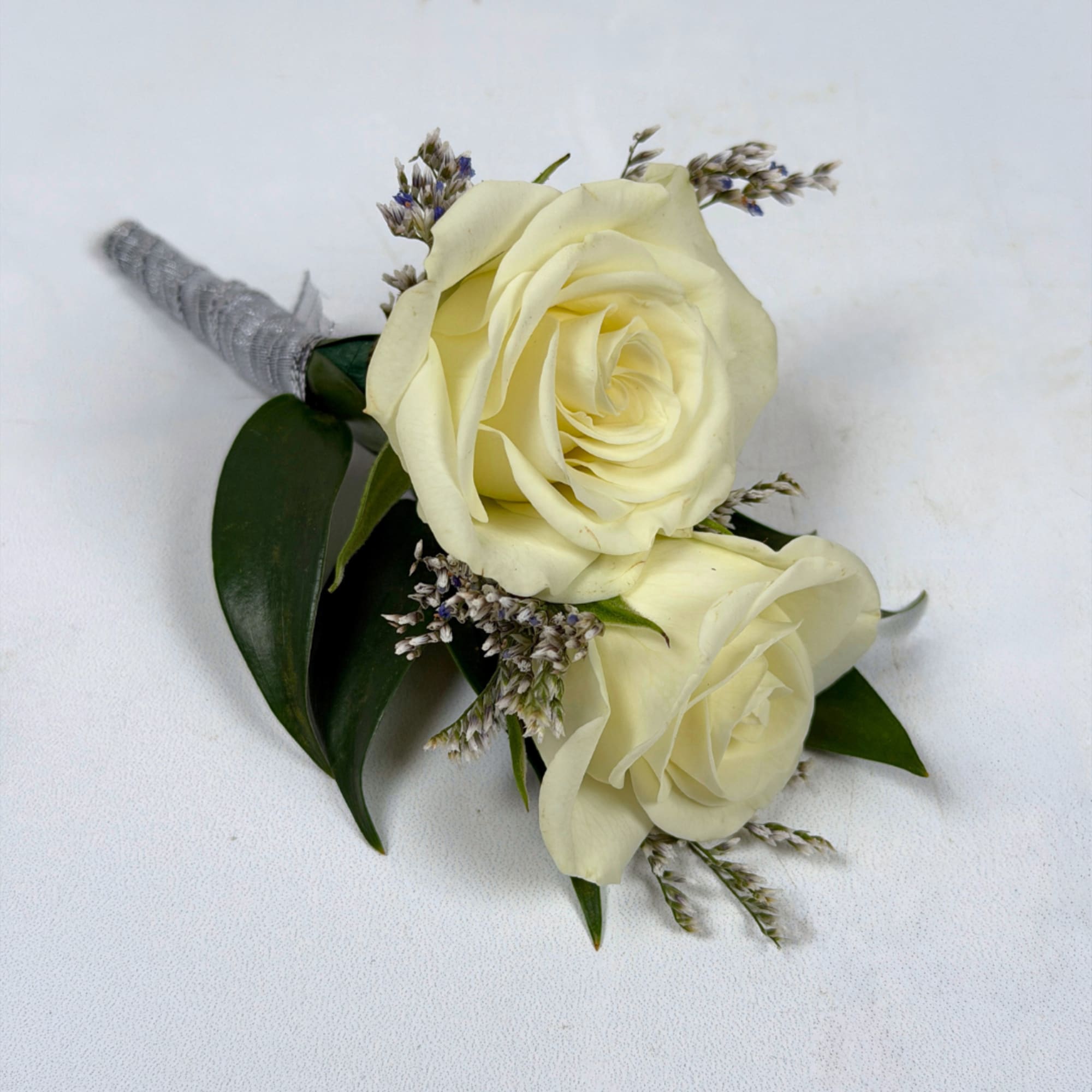 Two creamy ivory roses are center stage in our Opal Boutonniere, a
