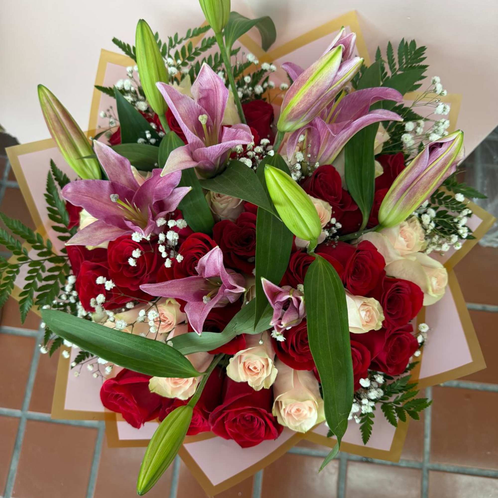 Bouquet of red and cream roses with pink lilies