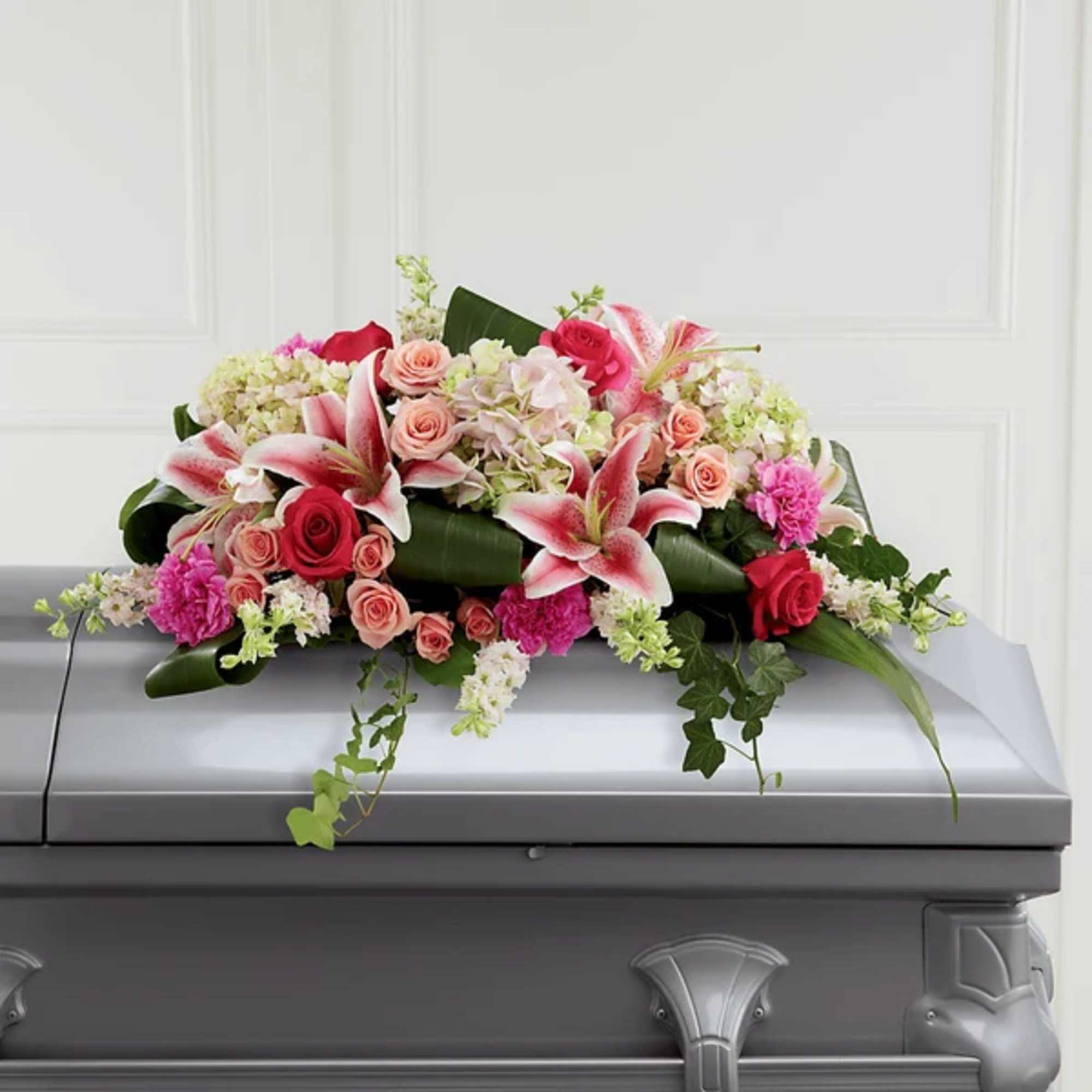 Pink and white floral casket spray with roses and lilies
