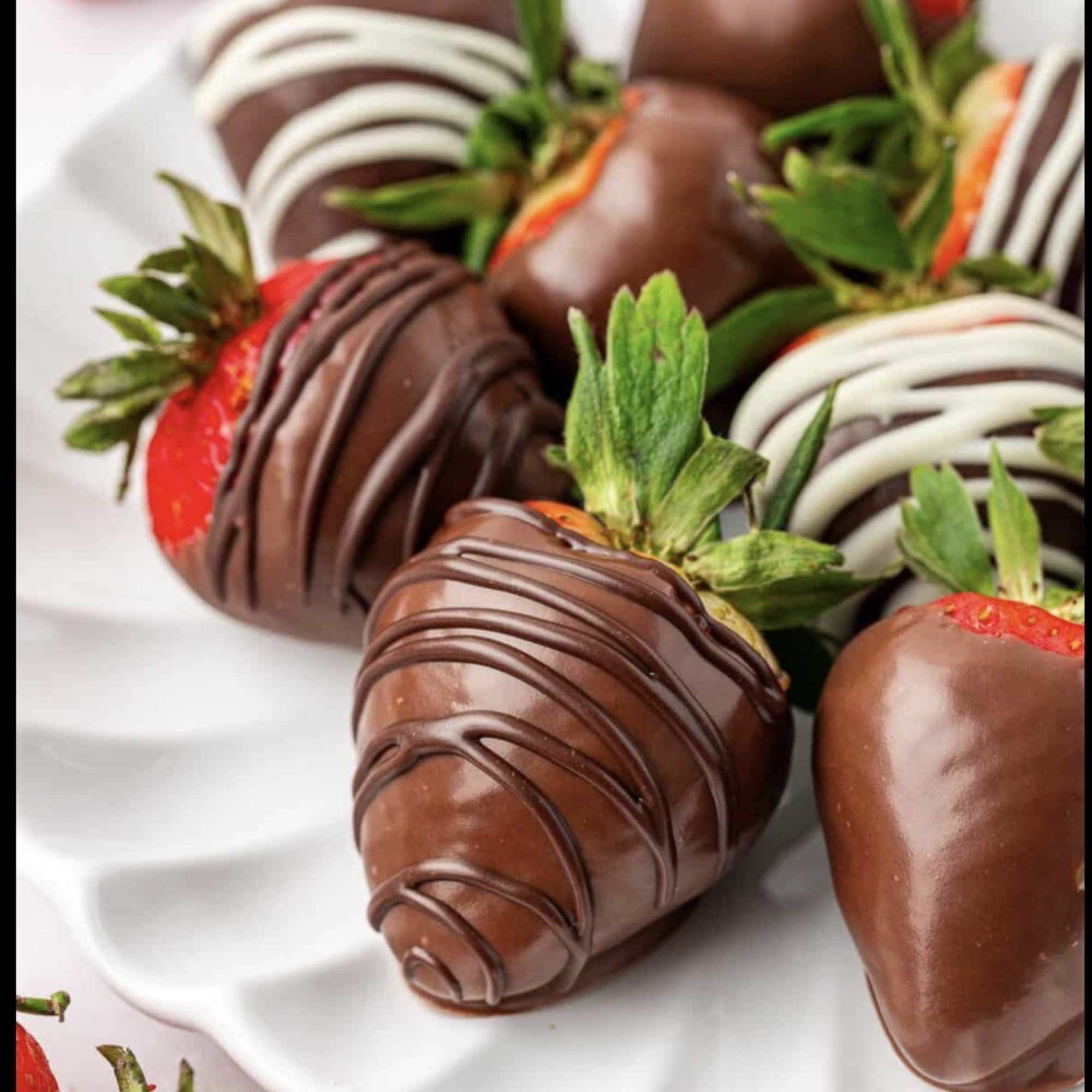 Chocolate-covered strawberries on a white plate