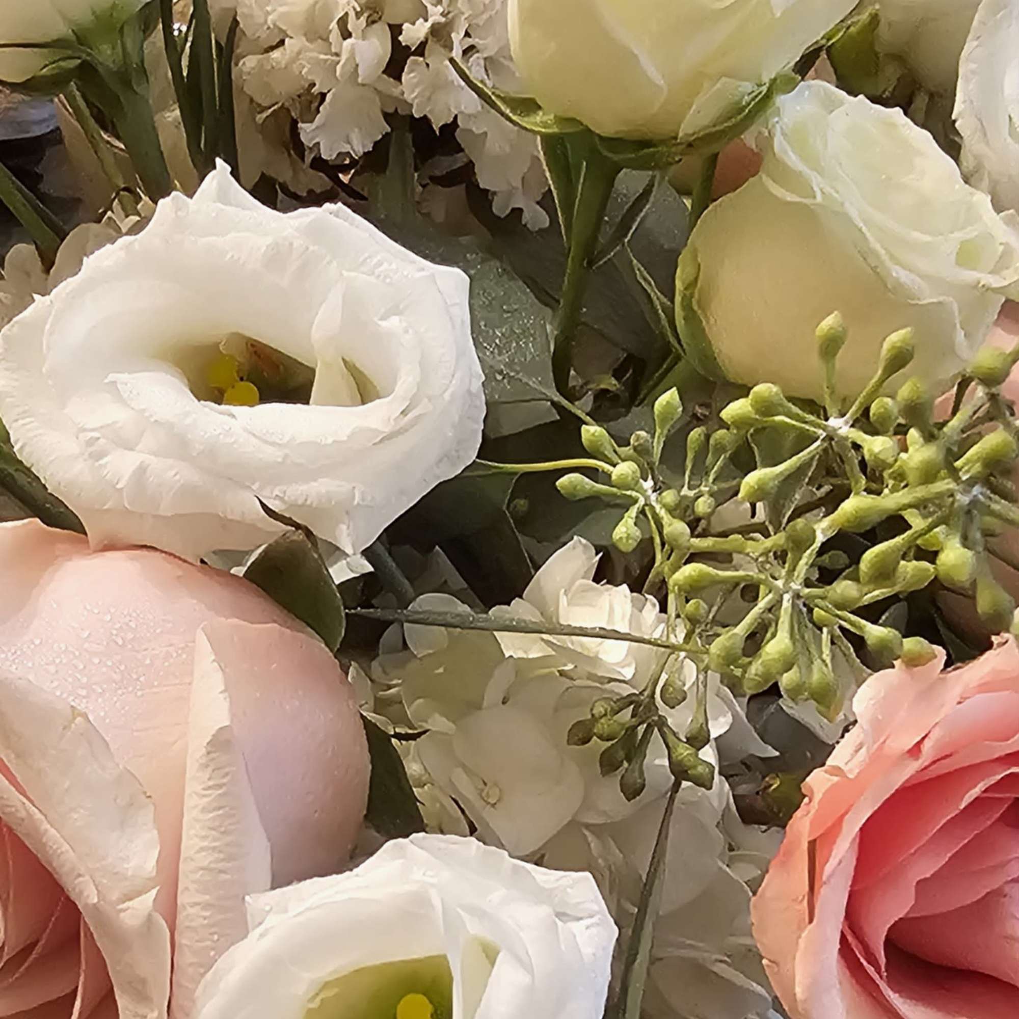 Close-up bouquet of white and pink roses with white lisianthus